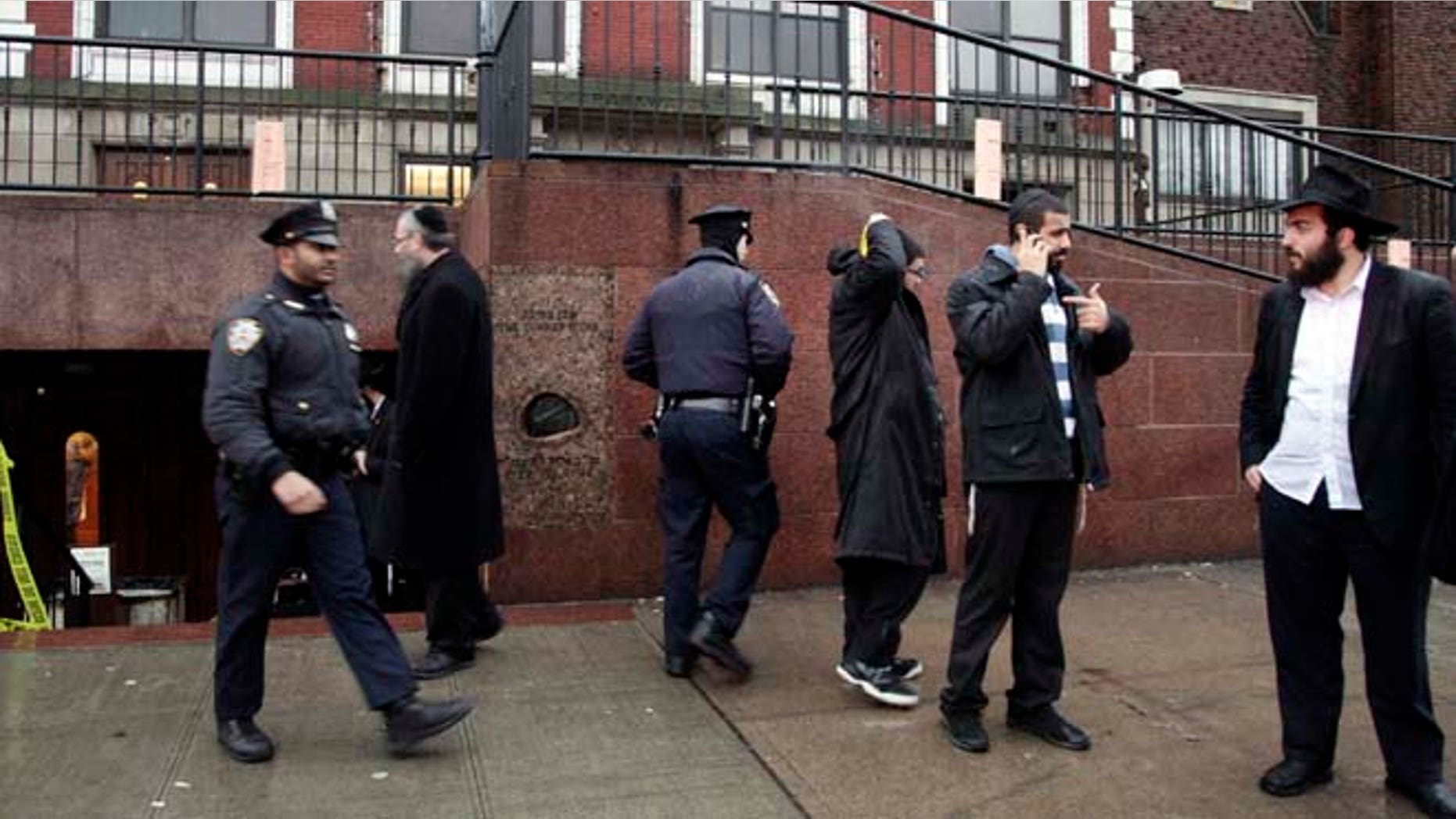 Dec. 9, 2014: Members of the Lubavitch community and police officers stand outside Chabad-Lubavitch Hasidic headquarters, in New York.