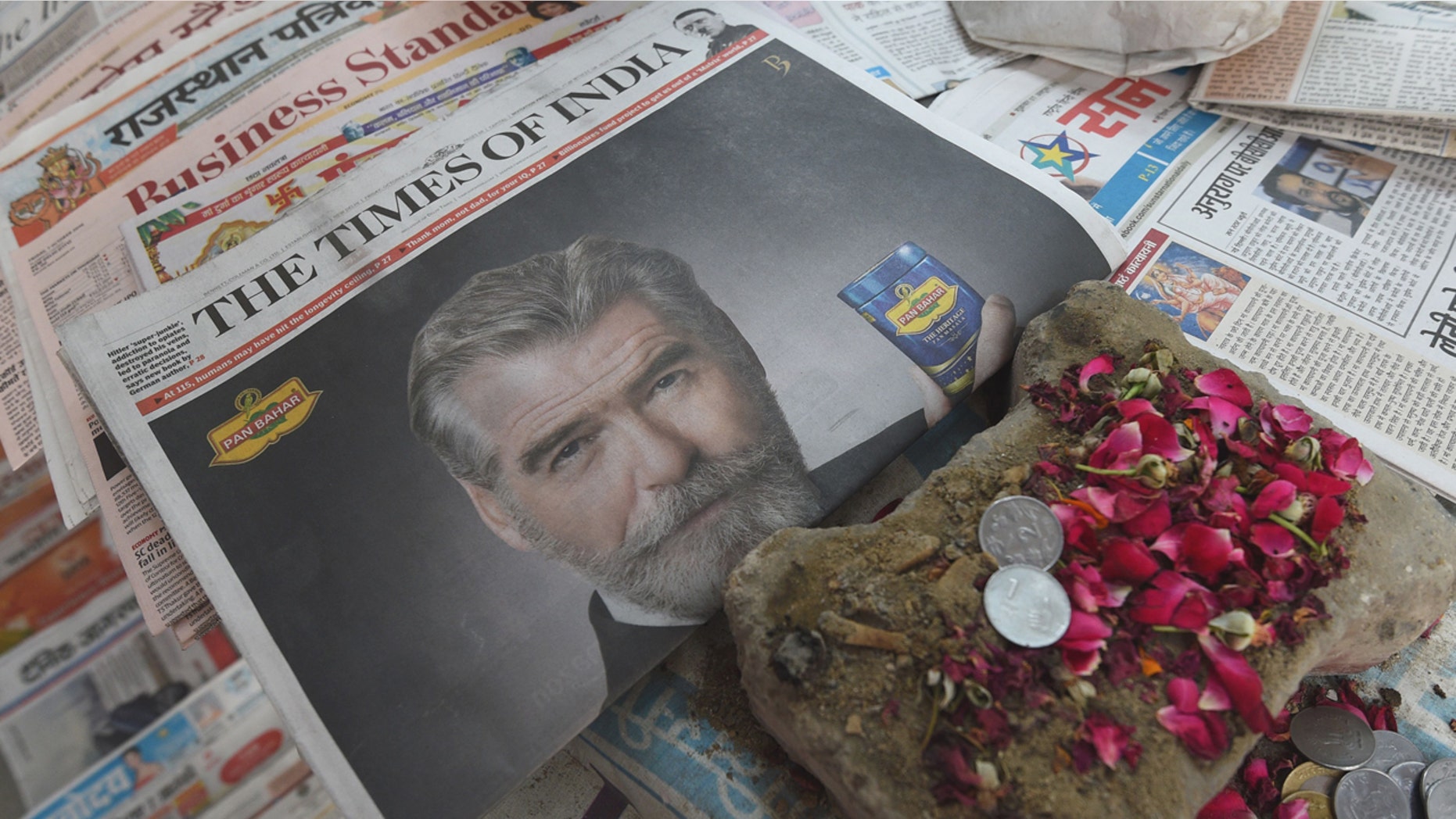A newspaper with a front page advertisment of former 007 star Pierce Brosnan endorsing an Indian mouth freshener, is seen on the streets of New Delhi on October 7, 2016.
Former 007 star Pierce Brosnan sparked ridicule on social media October 7, 2016 by starring in a new James Bond-style spoof commercial for an Indian mouth freshener that left fans shaken and stirred. / AFP / DOMINIQUE FAGET (Photo credit should read DOMINIQUE FAGET/AFP/Getty Images)