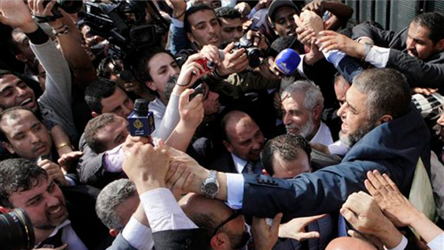 April 5, 2012: Muslim Brotherhood presidential hopeful Khairat el-Shater, right, is surrounded by hundreds of supporters and cameramen in Cairo.