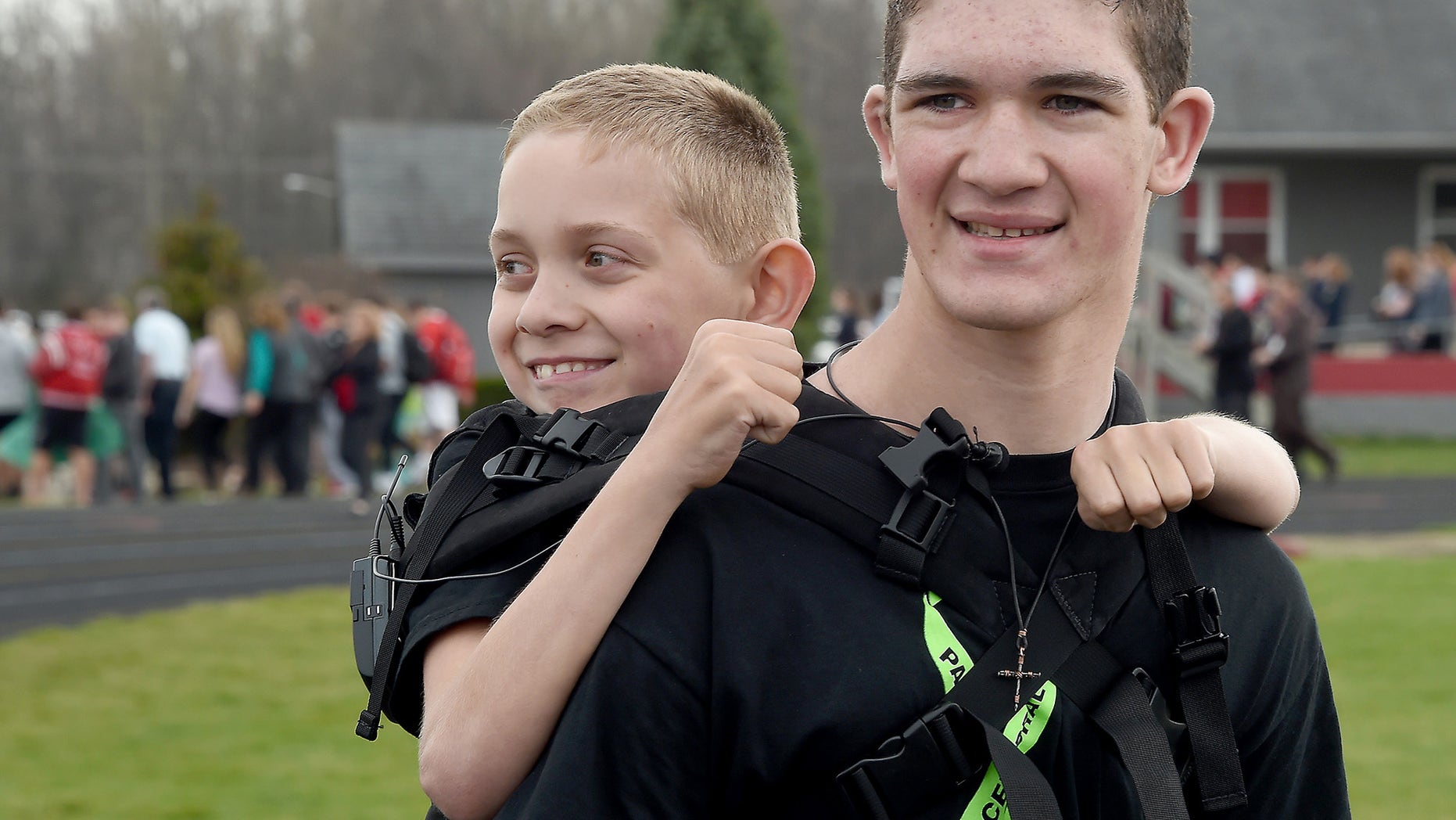 Hunter Gandee, 16, and his brother Braden, 9, start their third Cerebral Palsy Swagger walk at Bedford Community Stadium Wednesday at Bedford High School are cheered on as they leave. The walk is 111 miles and will end at the Capitol in Lansing, Mich., Monday, April 25. Hunter Gandee will carry Braden for the entire walk to bring more awareness to Cerebral Palsy, but this year Braden will walk the last half mile to the Capitol. (Tom Hawley/The Monroe News via AP)