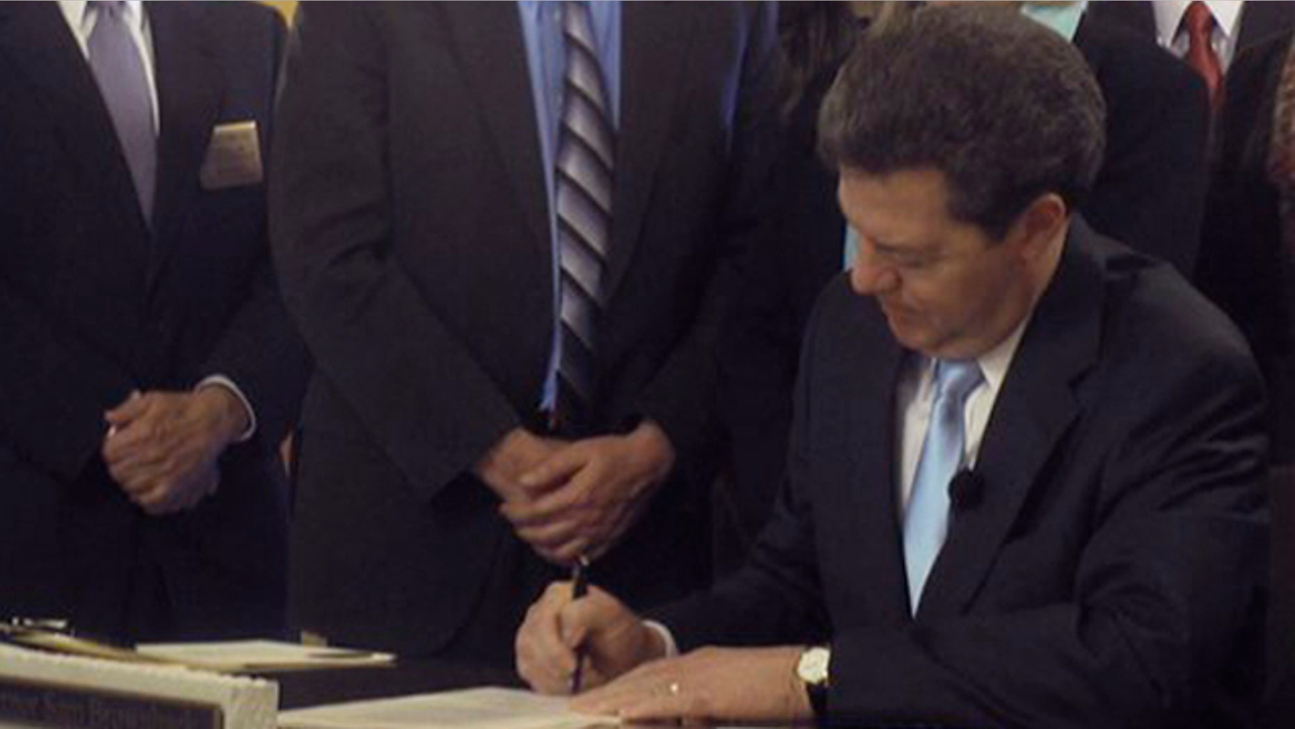 Kansas Gov. Sam Brownback signs an abortion restriction bill April 12 at the Statehouse in Topeka.
