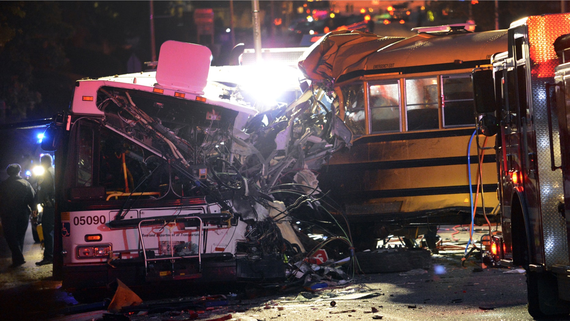 Fire department and rescue officials are at the scene of an early morning fatal collision between a school bus and a commuter bus Tuesday, Nov. 1, 2016, in Baltimore. (Jeffrey F. Bill/Baltimore Sun via AP)
