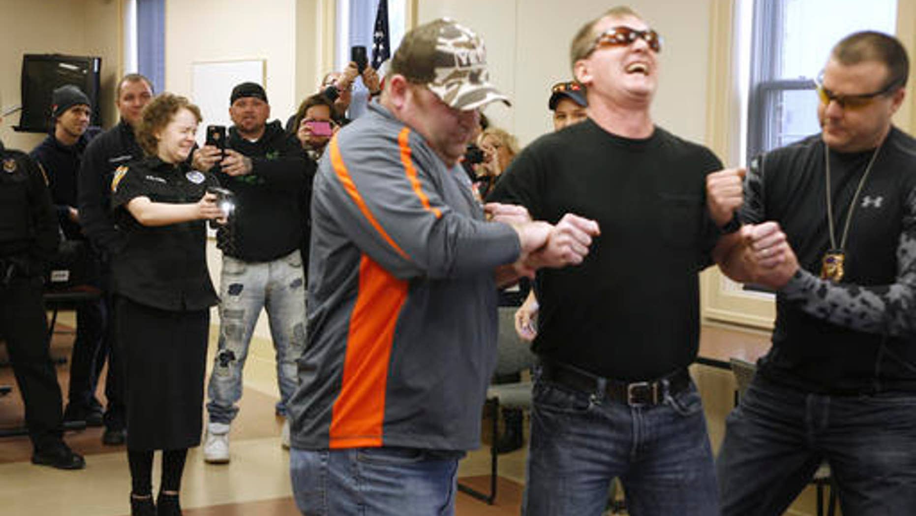 Alyssa Elkins, 16, uses a Taser on Newark Police Sgt. Doug Bline at the Newark, Ohio Police headquarters on Sunday, Jan. 29, 2017. Police helped Elkins, a teenage leukemia patient cross off a bucket-list item that was seriously shocking; she wanted to use a stun gun on someone. (Alan Miller/The Columbus Dispatch via AP)