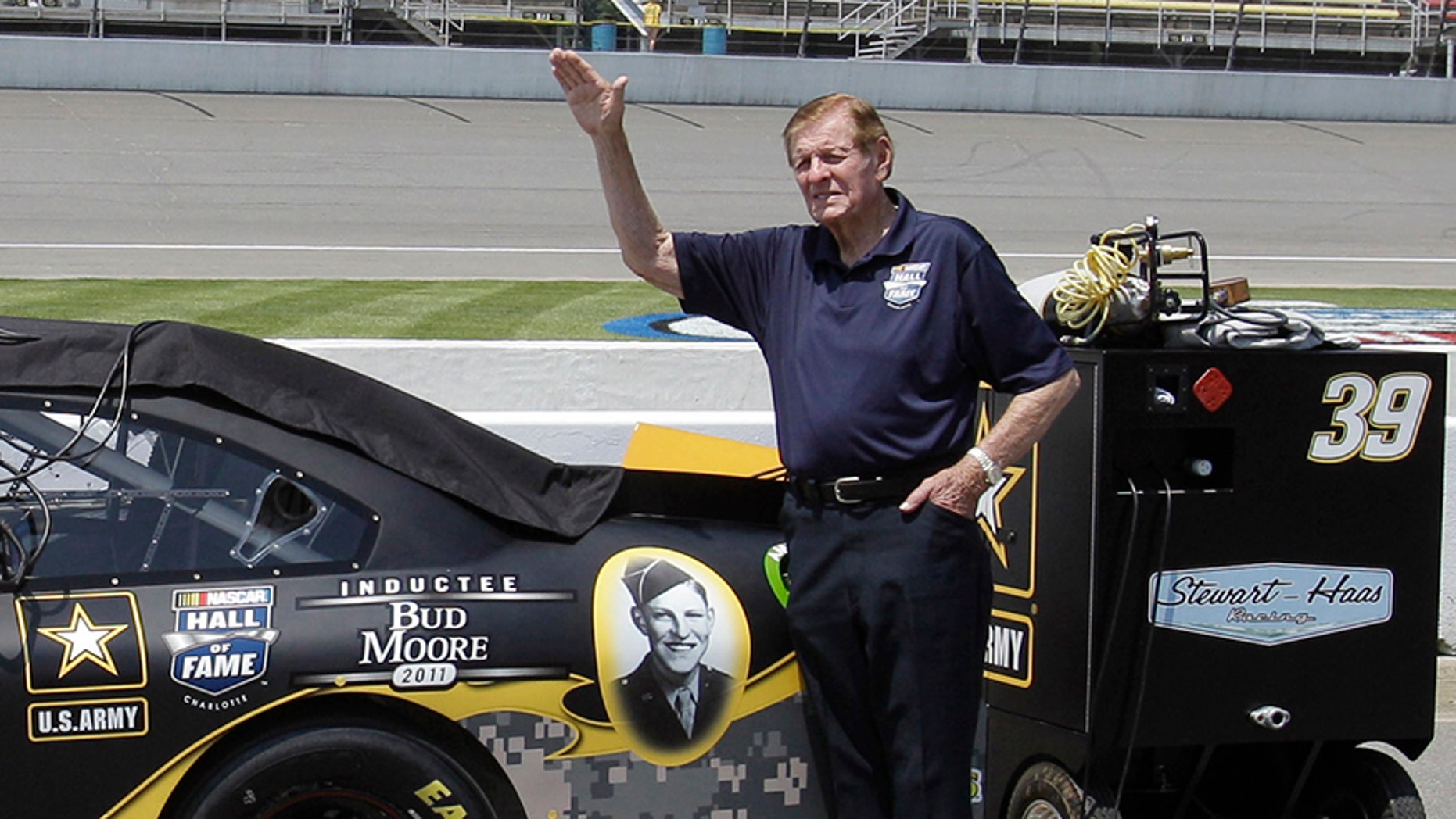 FILE - In this June 18, 2011, file photo, NASCAR Hall of Famer Bud Moore stands next to Ryan Newman's car before qualifying laps for a NASCAR Sprint Cup Series auto race at Michigan International Speedway in Brooklyn, Mich. NASCAR Hall of Famer Bud Moore, a World War II veteran awarded five Purple Hearts and two Bronze Stars, has died. He was 92. NASCAR announced the death of Moore, born Walter Moore Jr., on Tuesday, Nov. 28, 2017. No details were given, but Moore lived in Spartanburg, South Carolina.(AP Photo/Carlos Osorio)