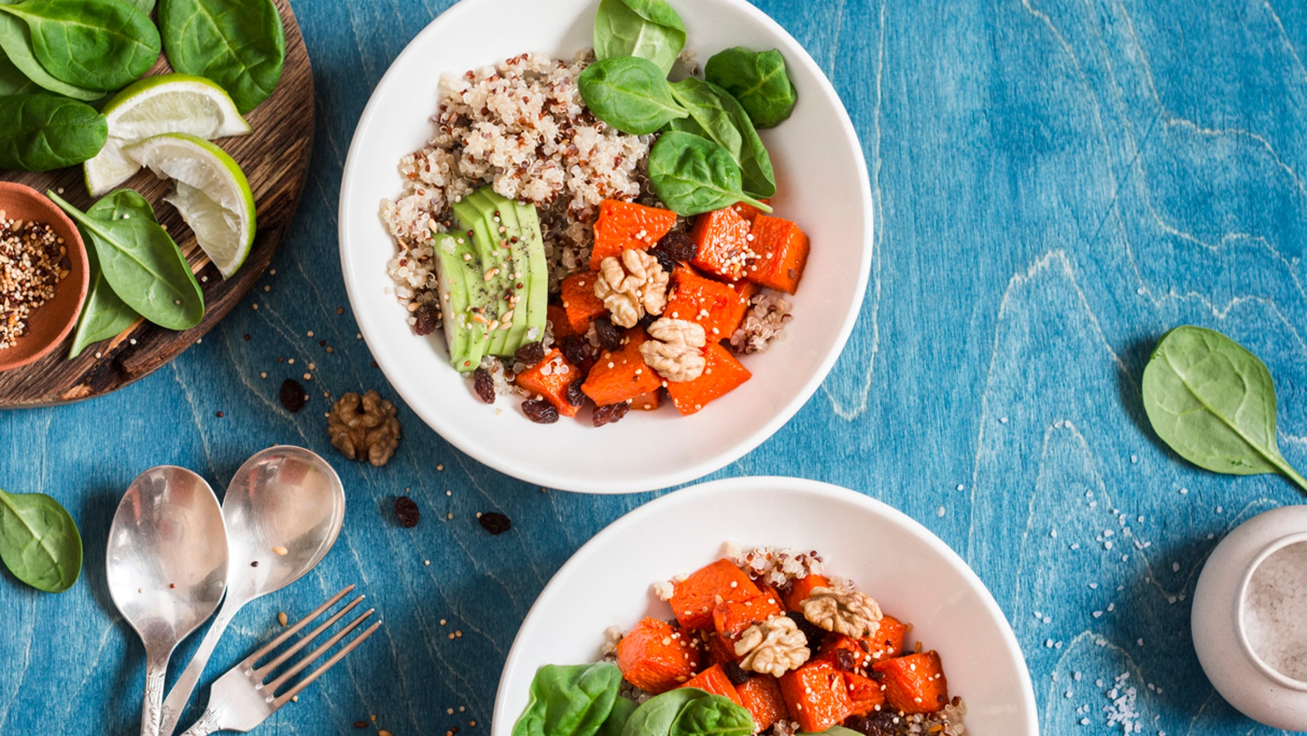 Quinoa with pumpkin, spinach and avocado. Healthy quinoa bowl. On a blue background, top view. Flat lay