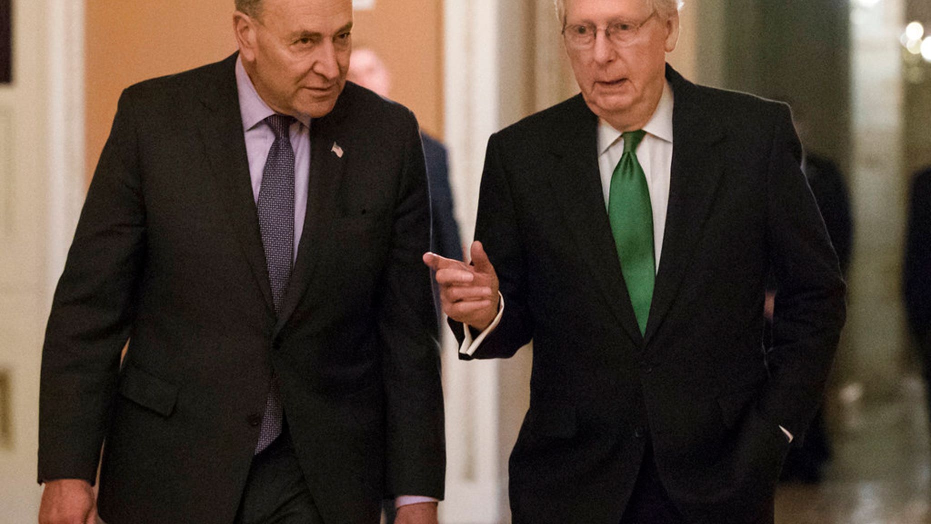 Senate Minority Leader Chuck Schumer, D-N.Y., left, and Senate Majority Leader Mitch McConnell, R-Ky., walk to the chamber after collaborating on an agreement in the Senate on a two-year, almost $400 billion budget deal that would provide Pentagon and domestic programs with huge spending increases, at the Capitol in Washington, Wednesday, Feb. 7, 2018. (AP Photo/J. Scott Applewhite)