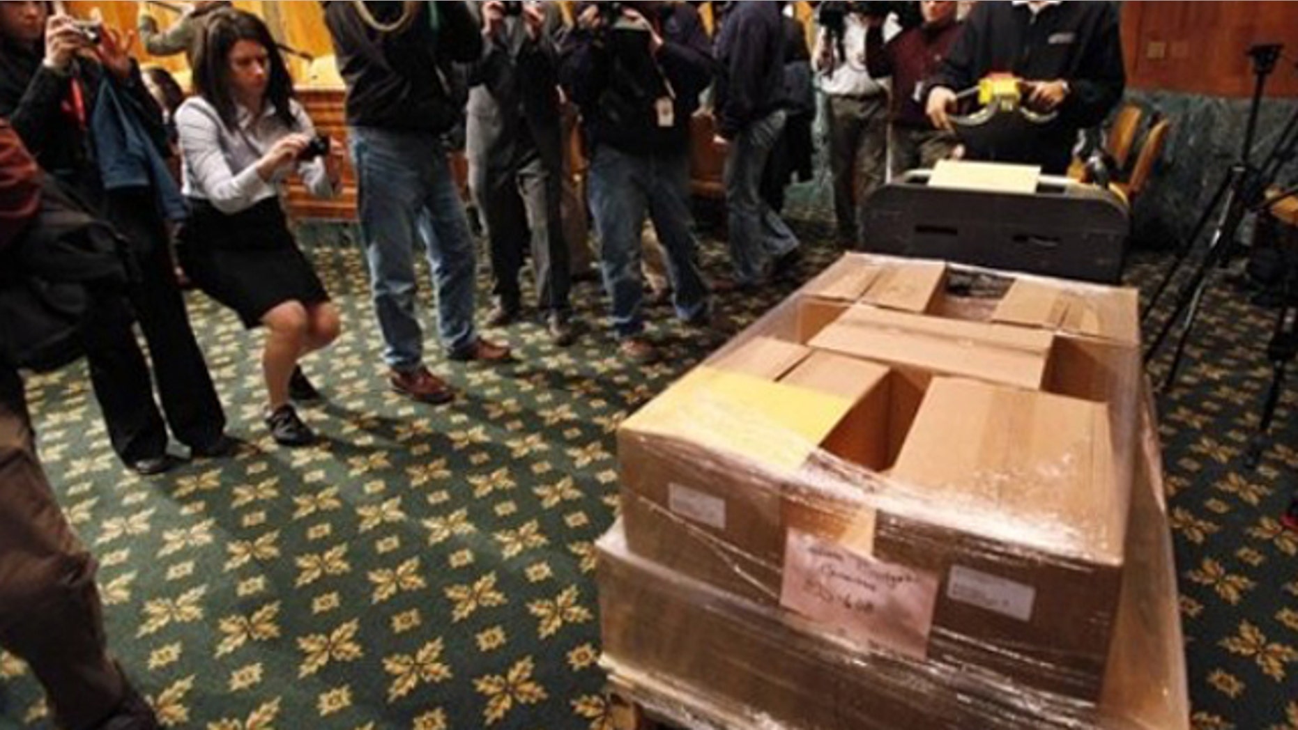 In this Feb. 1, 2010, photo, a Government Printing Office official delivers copies of President Obama's budget to the Senate Budget Committee on Capitol Hill.