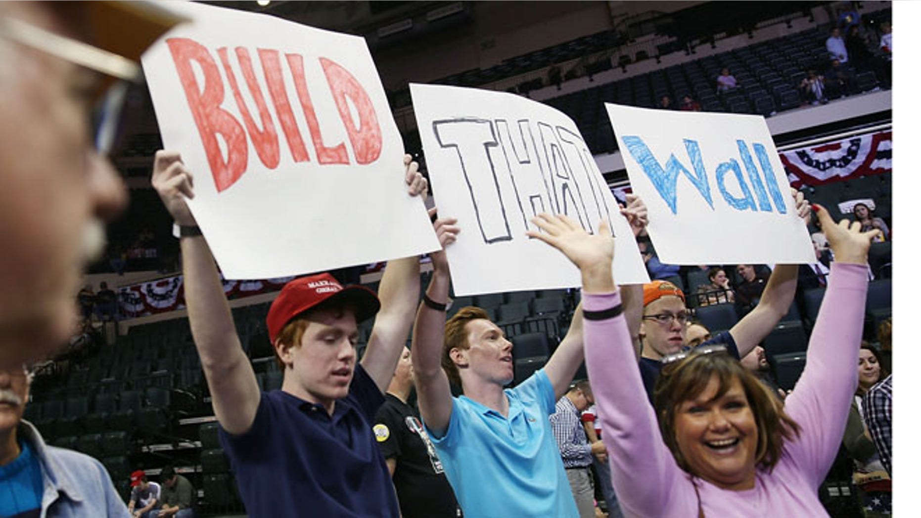 TAMPA, FL - FEBRUARY 12: People hold signs that read, " Build that Wall", as they wait for the start of a campaign rally for Republican presidential candidate Donald Trump at the University of South Florida Sun Dome on February 12, 2016 in Tampa, Florida. The process to select the next Democratic and Republican Presidential candidate continues. (Photo by Joe Raedle/Getty Images)