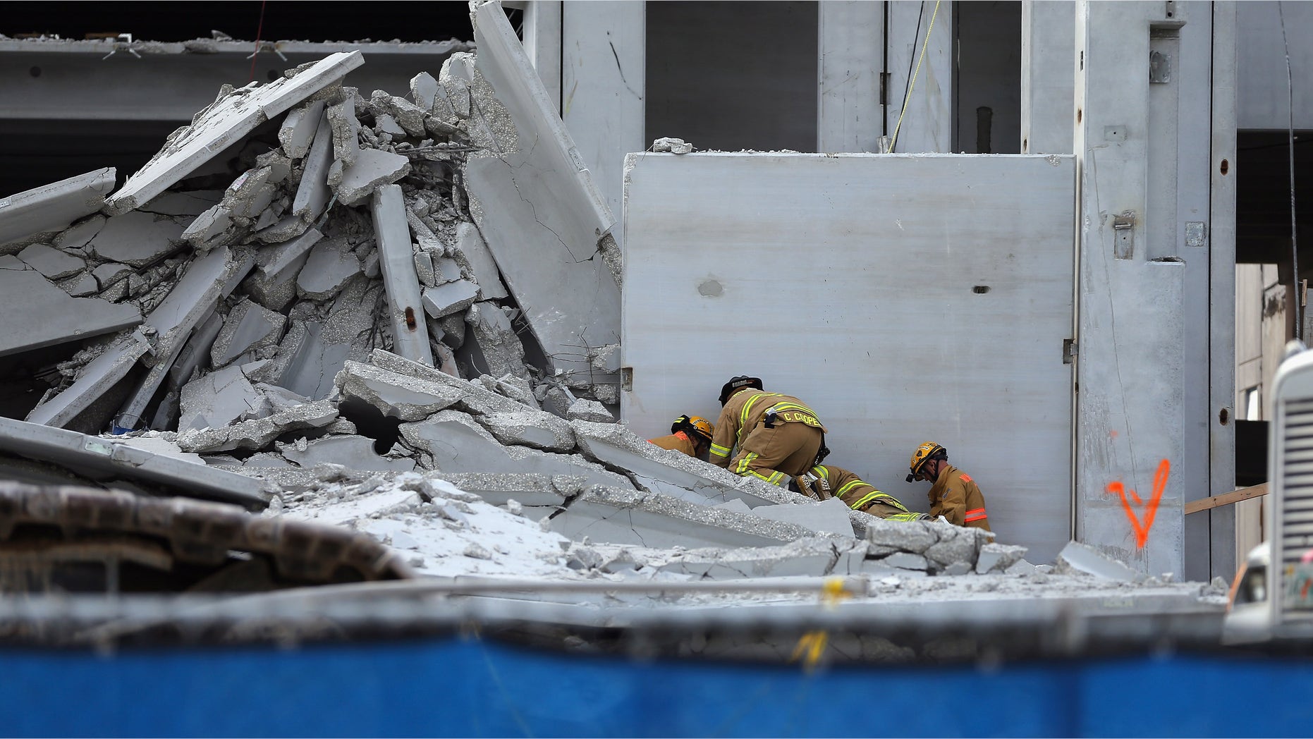 DORAL, FL - OCTOBER 10: Miami-Dade Rescue workers prepare to pull a body out of the rubble of a four-story parking garage that was under construction and collapsed at the Miami Dade College?s West Campus on October 10, 2012 in Doral, Florida. Early reports indicate that one person was killed in the collapse, at least seven people injured and one person may still be trapped in the rubble. (Photo by Joe Raedle/Getty Images)