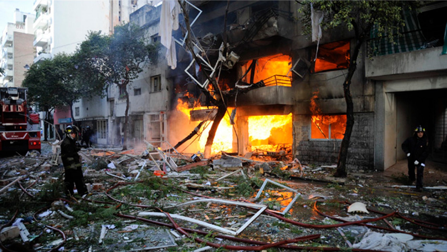 Aug. 6, 2013: Firemen stand in debris caused by a gas explosion that has severely damaged a multi-story apartment building in Rosario, Argentina.