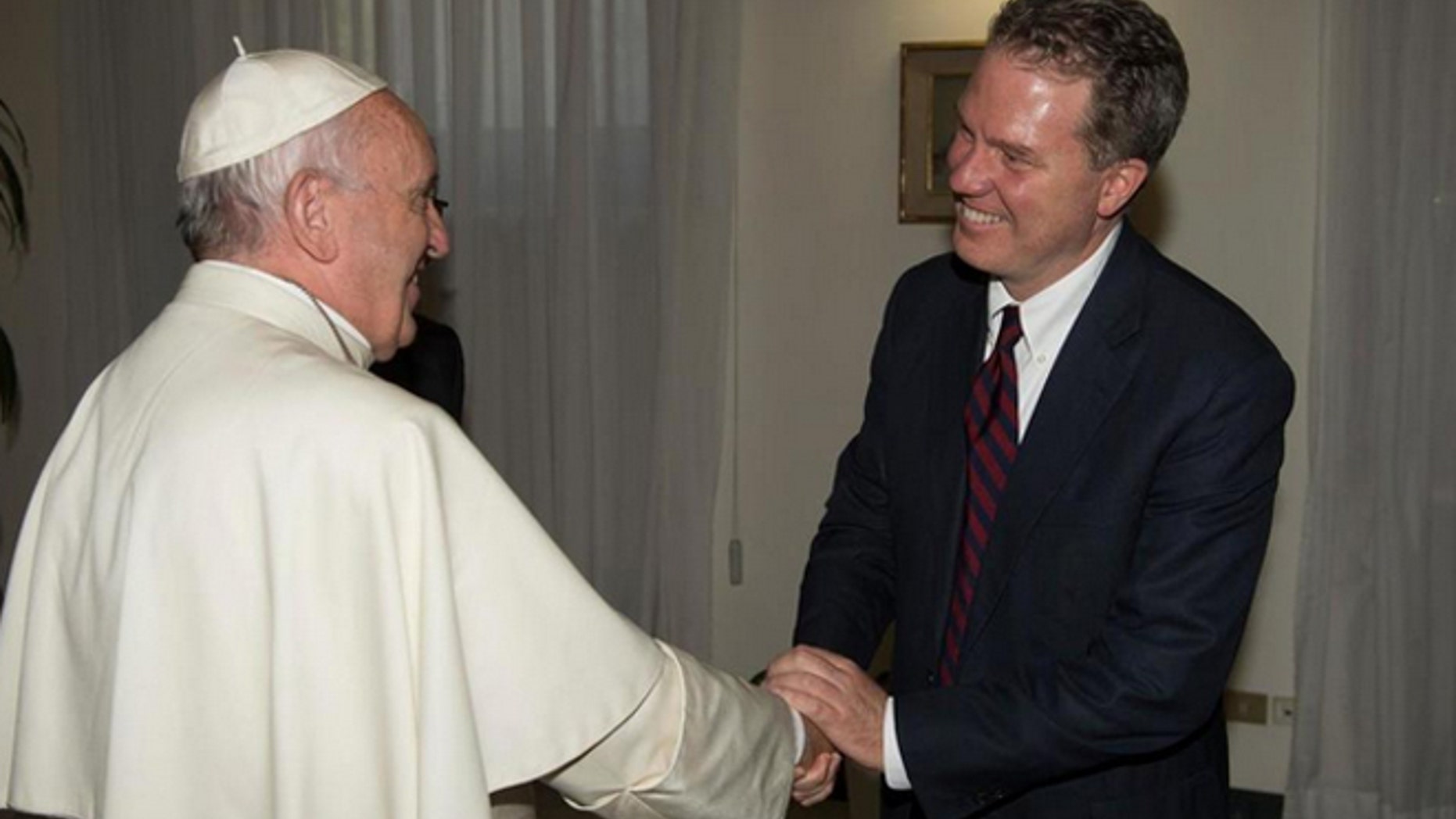 Pope Francis shakes hands with Greg Burke at the Vatican on Monday. (L'Osservatore Romano/Pool photo via AP)