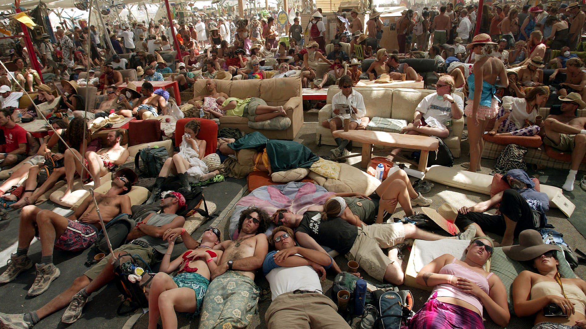 People seek shelter and rest inside the Center Camp Cafe at the Burning Man Festival in Black Rock City, Nevada, August 28, 2003. The Burning Man Festival has been celebrated annually since 1986 and draws around 20,000 people to the Black Rock Desert, celebrating radical self expression. - RTXM6VH