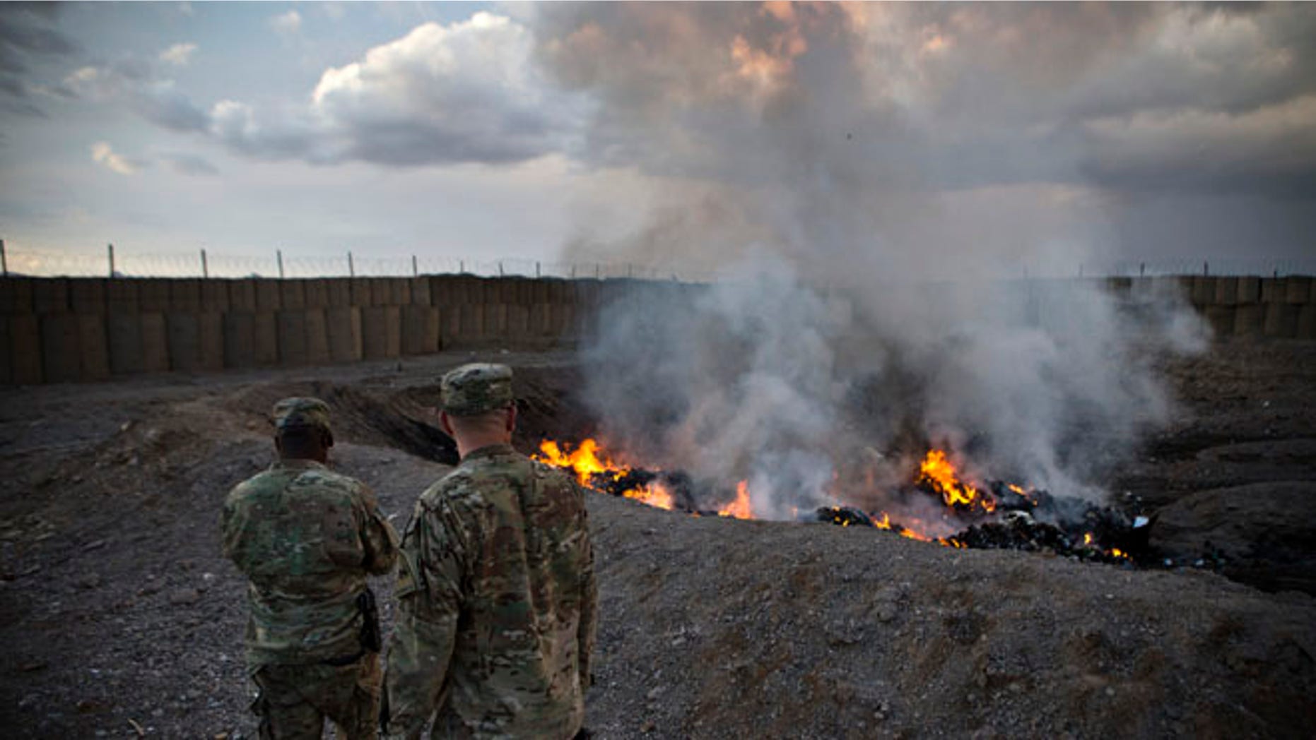 Feb. 4, 2013: U.S. Army soldiers watch garbage burn in a burn pit at Forward Operating Base Azzizulah in Maiwand District. Soldiers at FOB Sharana had to use a similar burn pit because incinerators were not completed.
