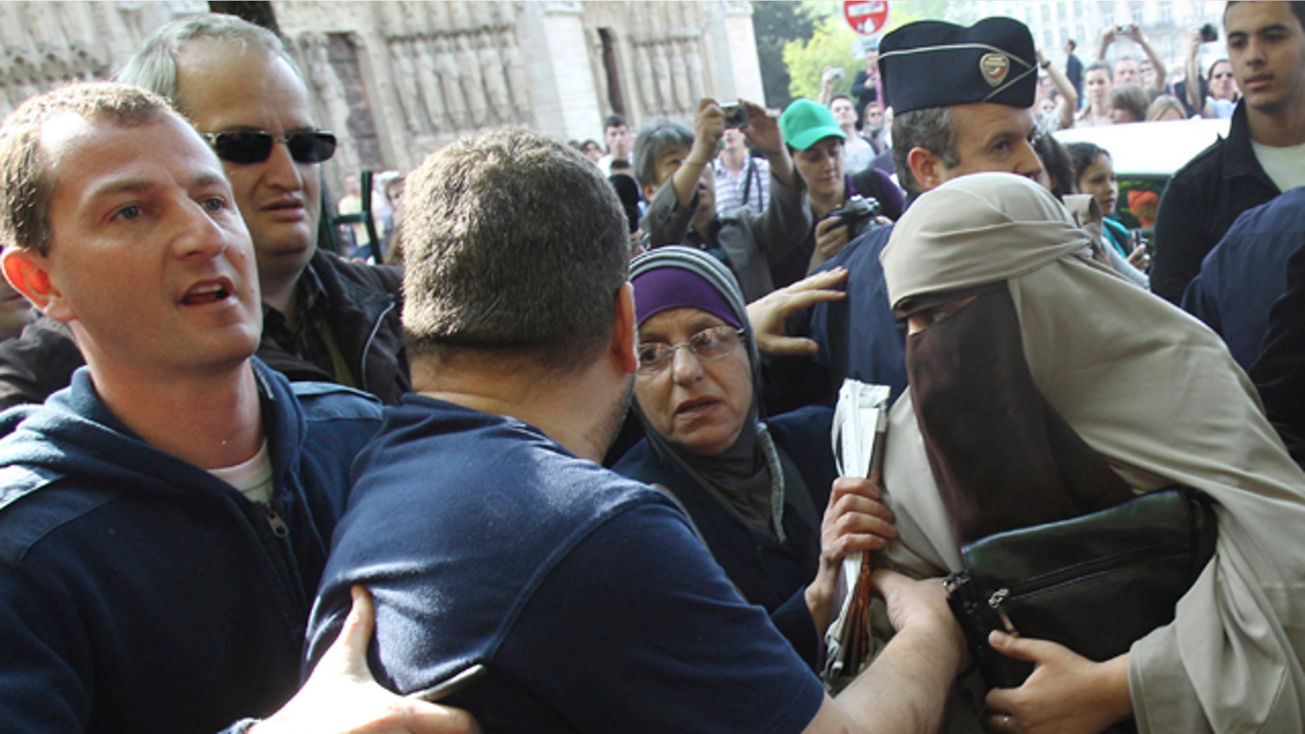 April 11: An unidentified veiled woman, right, is taken away by plain clothed police officers, left and second left, as she is accompanied by two friends, center left and right, in Paris. France's new ban on Islamic face veils was met with a burst of defiance Monday, as several women appeared veiled in front of Paris' Notre Dame Cathedral and two were detained for taking part in an unauthorized protest. France on Monday became the world's first country to ban the veils anywhere in public. (AP)