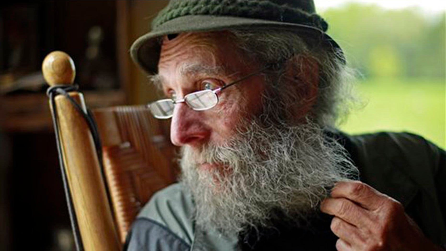 FILE- In May 23, 2014, file photo, Burt Shavitz pauses during an interview to watch a litter of fox kits play near his camp in Parkman, Maine. Shavitz, a former beekeeper, is the Burt behind Burt's Bees. A spokeswoman for Burts Bees said Shavtiz died Sunday, July 5, 2015, at his home in rural Maine. He was 80. (AP Photo/Robert F. Bukaty, File)