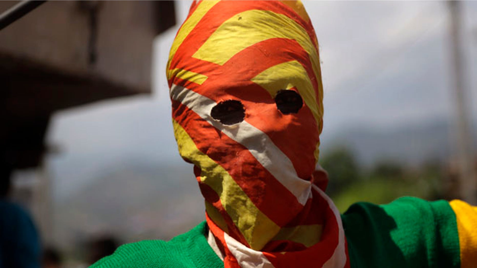 May 21, 2015: A masked Protester waits for police during clashes in the Nyakabyga neighborhood of Bujumbura, Burundi. (AP)