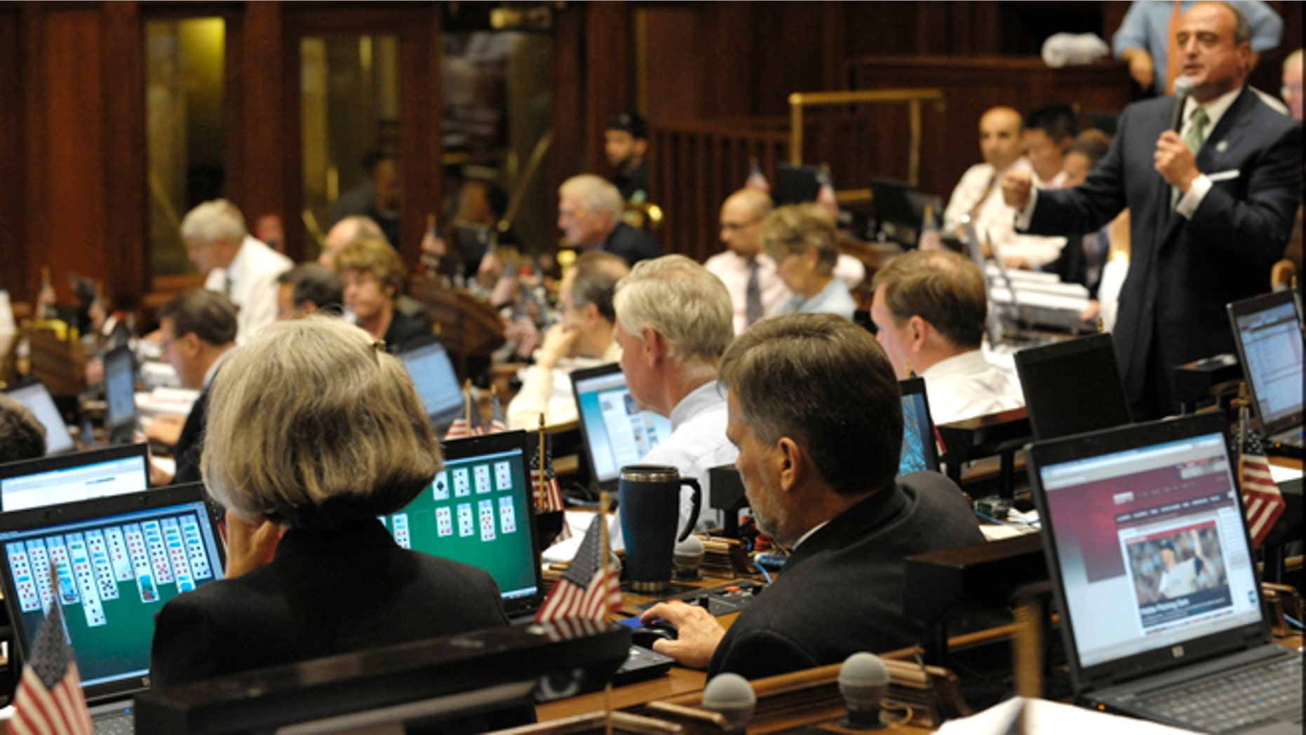 State legislators play solitaire and surf the internet on laptop computers while House Minority Leader Lawrence F. Cafero Jr. speaks prior to a vote on the state budget in 2009.