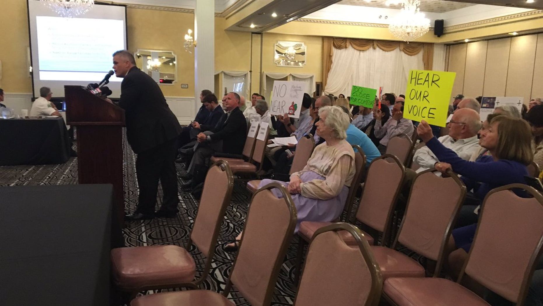 Opponents of the "guntry club" brought signs to the town hall meeting.
