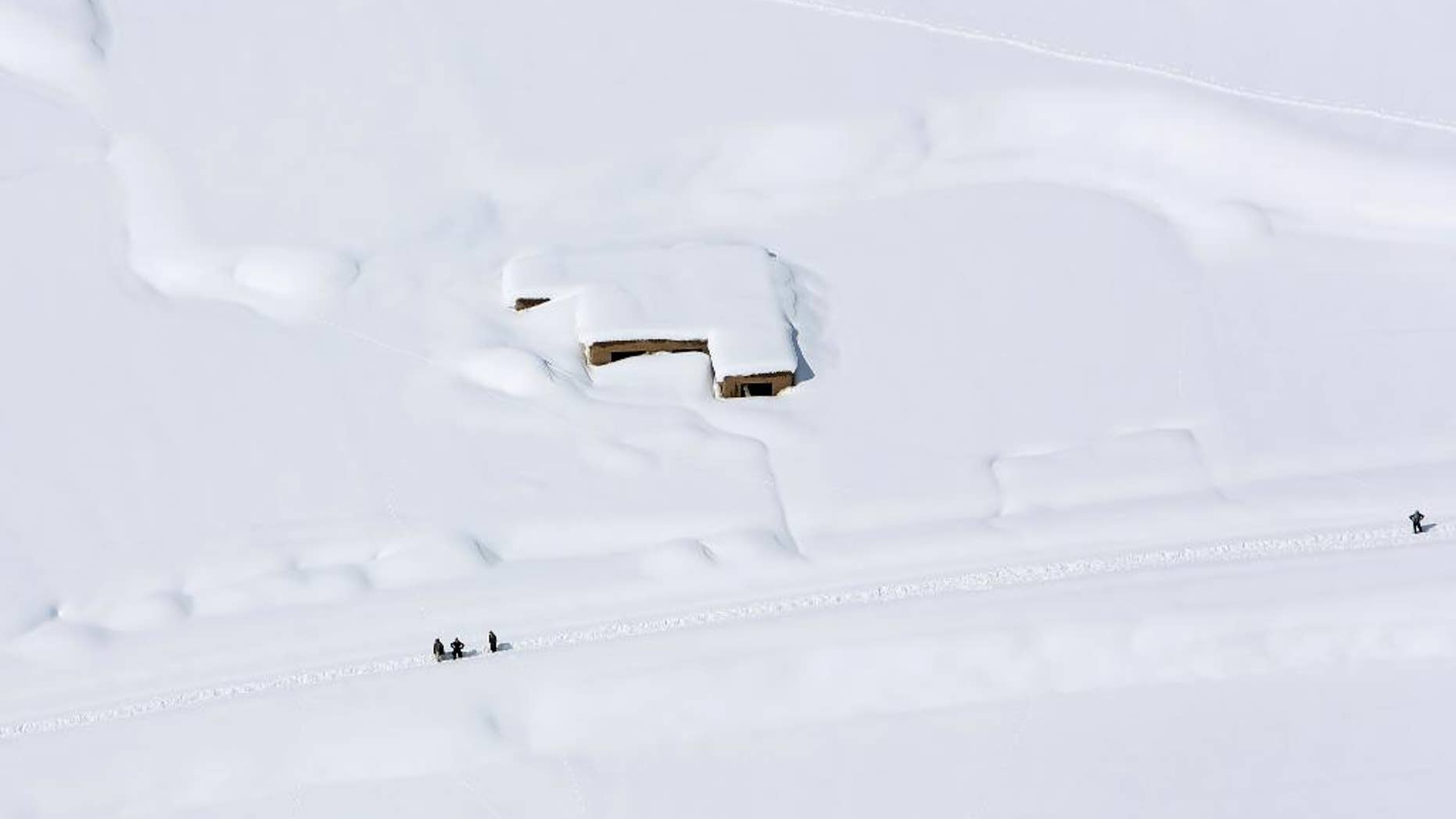 A house is covered with snow from an avalanche in the Paryan district of Panjshir province, north of Kabul, Afghanistan, Friday, Feb. 27, 2015. The death toll from severe weather that caused avalanches and flooding across much of Afghanistan has jumped to more than 200 people, and the number is expected to climb with cold weather and difficult conditions hampering rescue efforts, relief workers and U.N. officials said Friday. (AP Photo/Rahmat Gul)