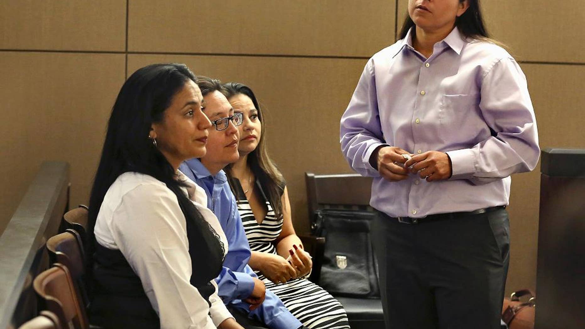 FILE - In this April 22, 2015 file photo, four San Antonio women known as the San Antonio 4 from right, Anna Vasquez, Elizabeth Ramirez, Kristie Mayhugh and Cassandra Rivera look on during a hearing in San Antonio, Texas. The Texas Court of Criminal Appeals ruled Wednesday, Nov. 23, 2016, that the four women who served almost 15 years in prison after being wrongfully convicted in 1998 of sexually assaulting two young girls should be exonerated of the charges. The majority opinion issued by the court declares that they are innocent and could make them eligible for millions in state compensation. (Bob Owen/The San Antonio Express-News via AP, File)