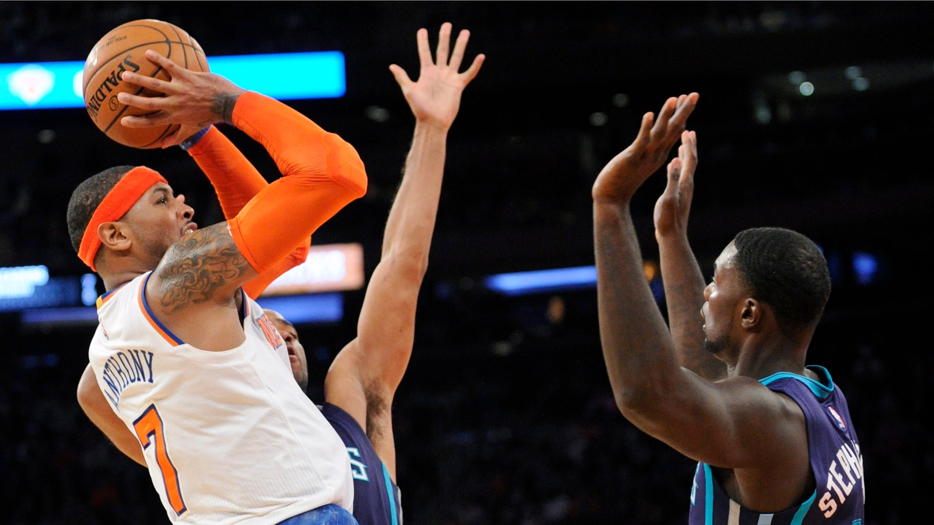 New York Knicks' Carmelo Anthony (7) attempts a shot as he is guarded by Charlotte Hornets' Gerald Henderson and Lance Stephenson, right, during the fourth quarter of an NBA basketball game Sunday, Nov. 2, 2014, at Madison Square Garden in New York. The Knicks won 96-93. (AP Photo/Bill Kostroun)