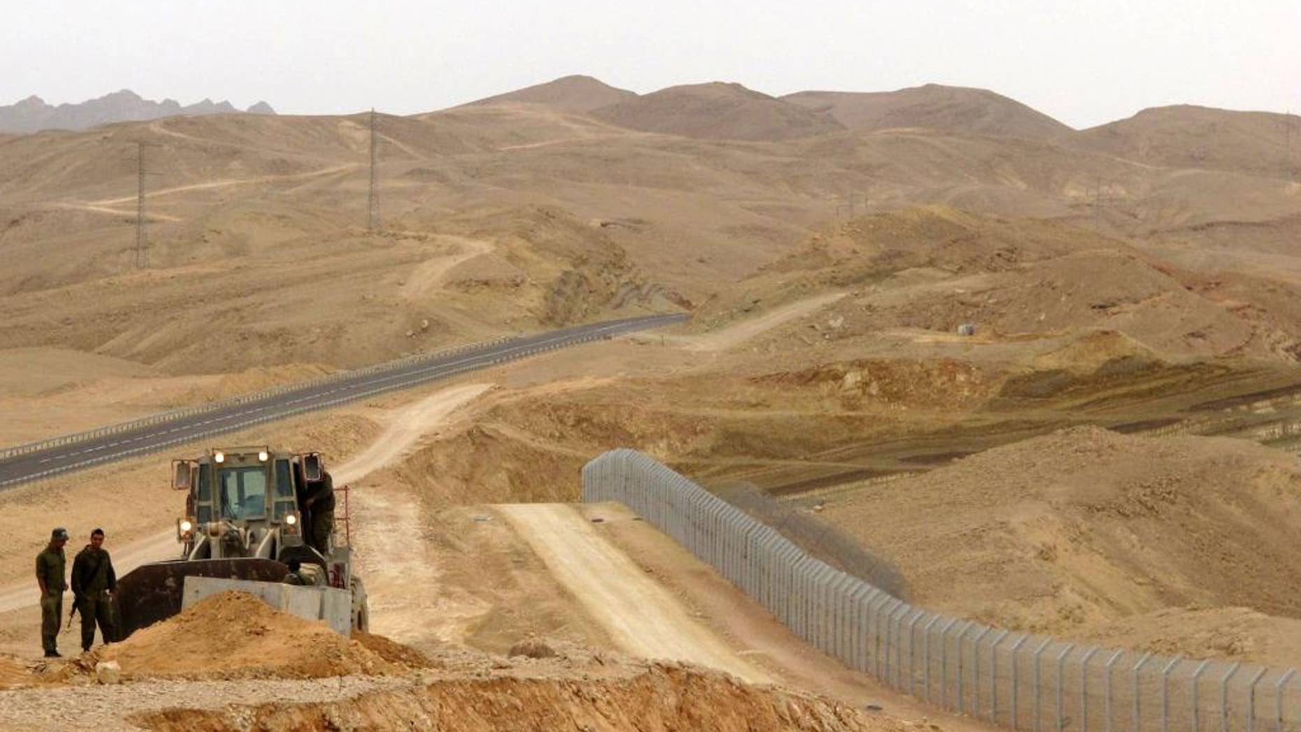 FILE - In this Feb. 15, 2012 photo, an Israeli bulldozer works at the site where Israel builds a barrier along the border with Egypt in southern Israel. Magal S3, the Israeli company that has built high-tech fences along the country's volatile borders is now trying to build a bridge to the Trump administration, hoping to use its experience to cash in on his plan to seal the border with Mexico. Magal S3 has been a major player in building barriers along Israel's northern and southern borders, as well as the massive separation barrier that snakes along the frontier with the West Bank. Its products include cameras, sophisticated sensors, robots and software to operate the systems. (AP Photo/Diaa Hadid, File)