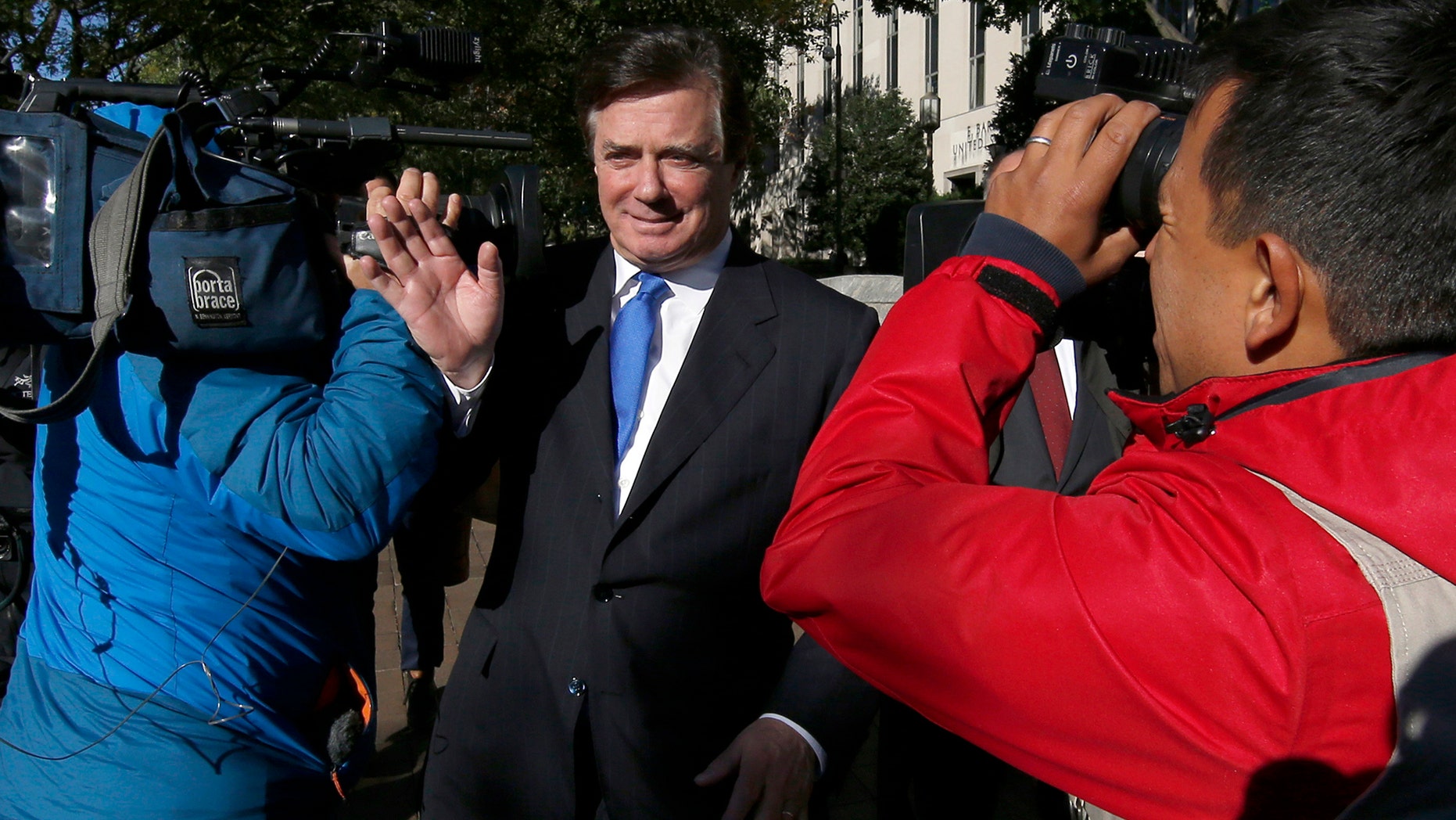 Paul Manafort makes his way through television cameras as he walks from Federal District Court in Washington, Monday, Oct. 30, 2017. Manafort, President Donald Trump's former campaign chairman, and Manafort's business associate Rick Gates have pleaded not guilty to felony charges of conspiracy against the United States and other counts. (AP Photo/Alex Brandon)