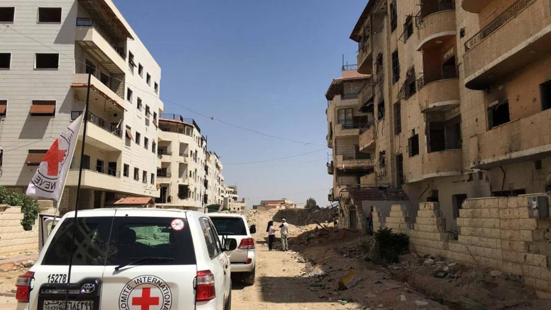 This image released by the International Committee for the Red Cross shows the first humanitarian aid convoy in Daraya, Syria on Wednesday, June 1, 2016. A besieged suburb of Syria's capital received humanitarian aid Wednesday for the first time since 2012, as the United Nations. The International Committee for the Red Cross (ICRC) reported that a joint convoy with the U.N. and the Syrian Arab Red Crescent entered the Damascus suburb of Daraya in the afternoon. The U.N. estimates that 4,000 to 8,000 people currently live in the suburb.(ICRC via AP)