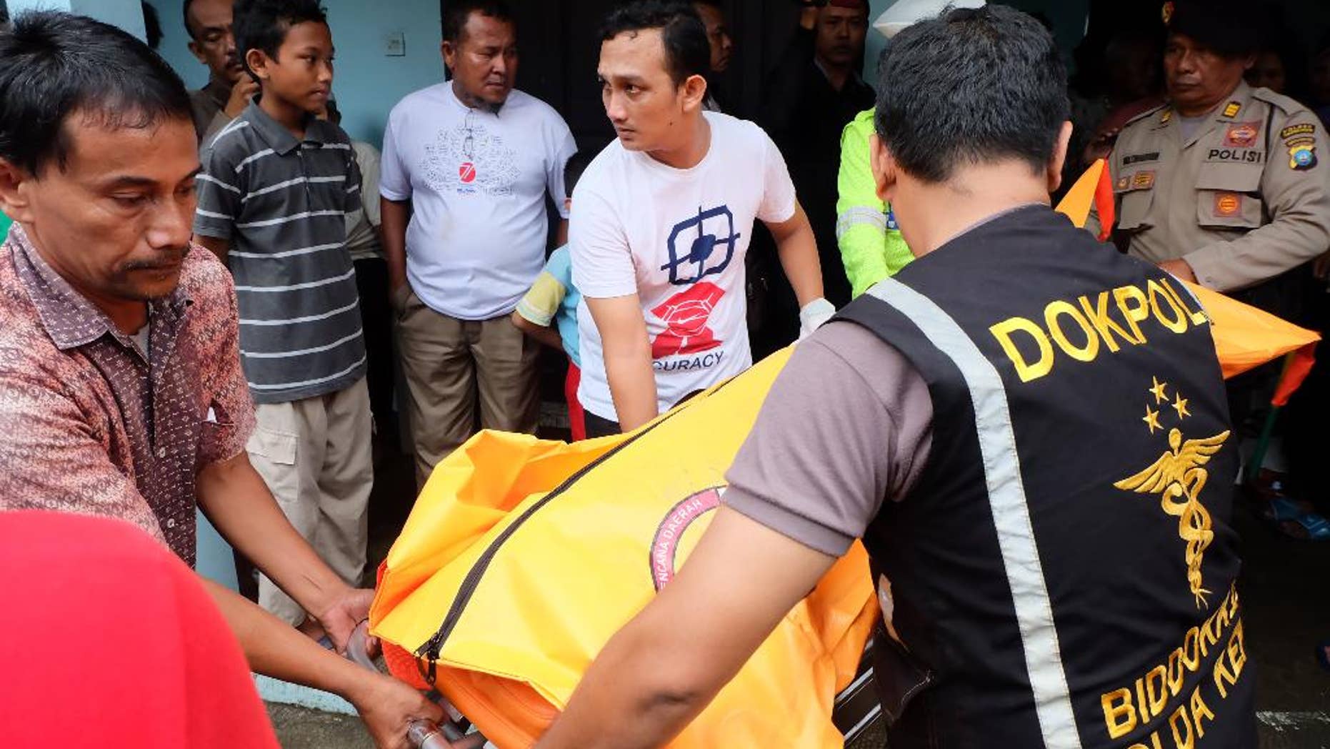 Indonesian police carry a body bag containing a victim of a capsized boat, at a hospital in Tanjungpinang, Bintan island, Indonesia, Sunday, Aug. 21, 2016. A number of people died and others were missing after a small wooden boat capsized in rough seas and sank Sunday off Indonesia's Bintan island, south of Singapore, Indonesian officials said.(AP Photo/Albert)