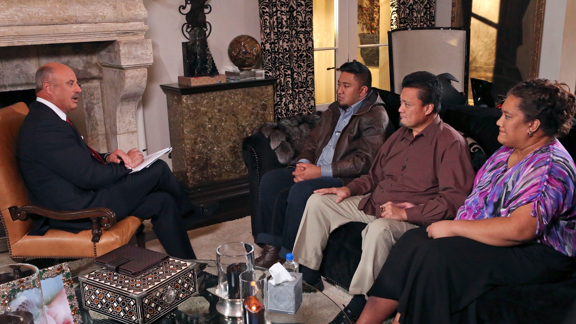 In this Jan. 24, 2013, photo provided by CBS Television Distribution/Peteski Productions, talk show host Dr. Phil McGraw, left, interviews Ronaiah Tuiasosopo and his parents Titus and Cheannie Tuiasosopo during taping for the "Dr. Phil Show" in Los Angeles. The program, which aired Thursday, Jan. 31, and Friday, Feb. 1, was the first on-air interview of Ronaiah, the man who allegedly concocted the girlfriend hoax that ensnared Notre Dame football star Manti Te'o. (AP Photo/CBS Television Distribution/Peteski Productions)
