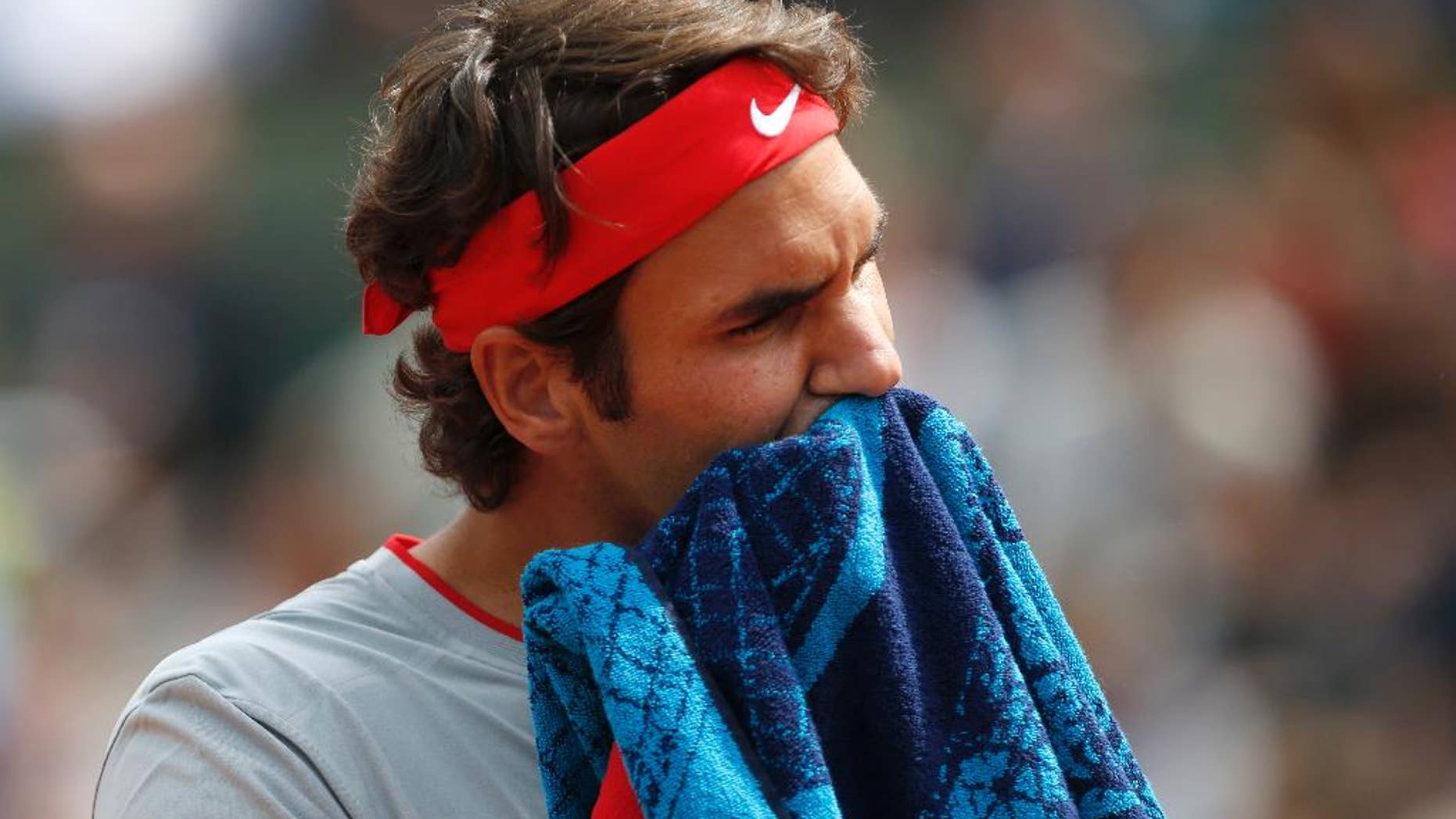 Switzerland's Roger Federer wipes his face during the first round match of the French Open tennis tournament against Slovakia's Lukas Lacko at the Roland Garros stadium, in Paris, France, Sunday, May 25, 2014. (AP Photo/Darko Vojinovic)