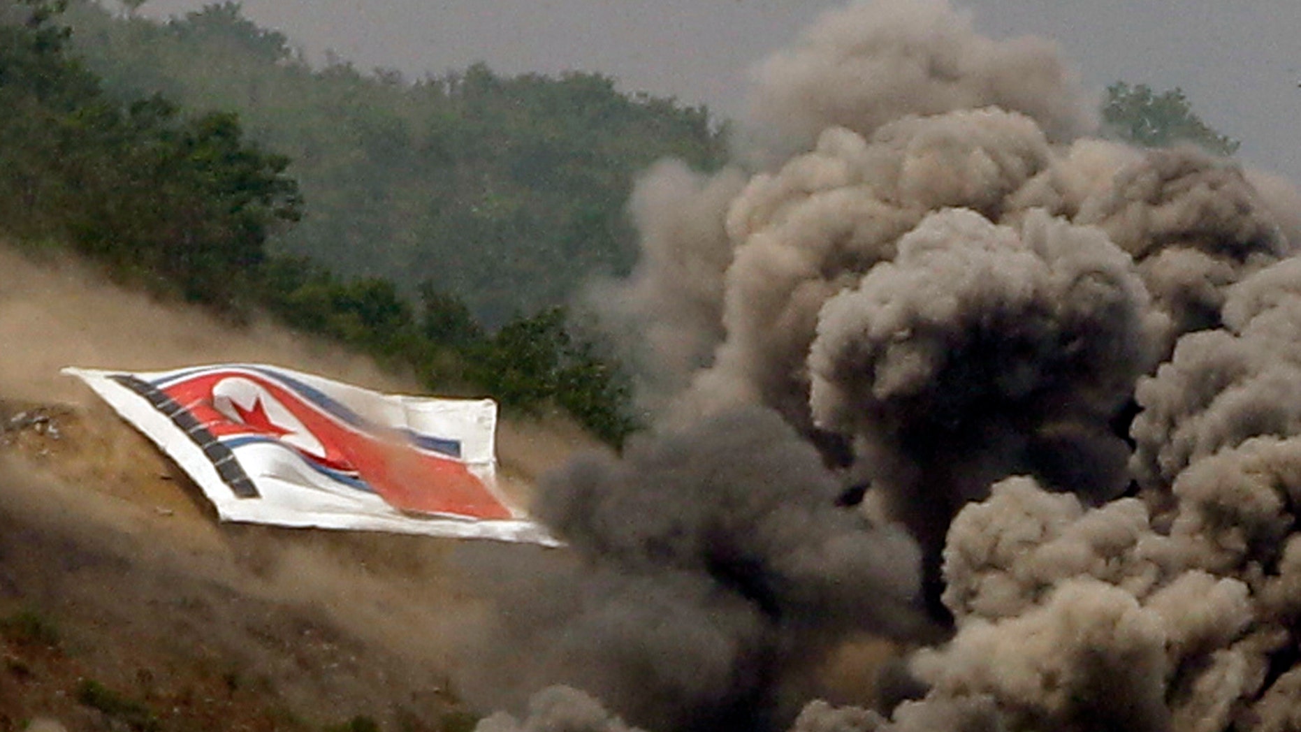June 19, 2012: In this photo, smoke rises from explosions near the North Korean flag during South Korea-U.S. joint military live-fire drills at Seungjin Fire Training Field in Pocheon, South Korea, near the border with North Korea.