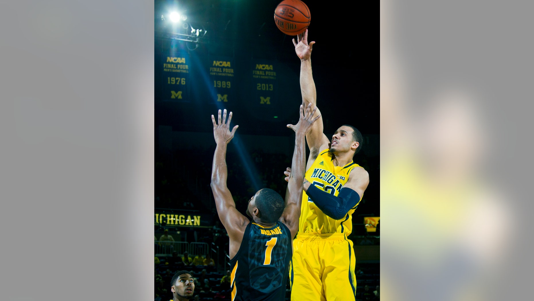 Michigan forward Jordan Morgan, right, takes a shot over Iowa forward Melsahn Basabe (1) in the first half of an NCAA college basketball game in Ann Arbor, Mich., Wednesday, Jan. 22, 2014. (AP Photo/Tony Ding)