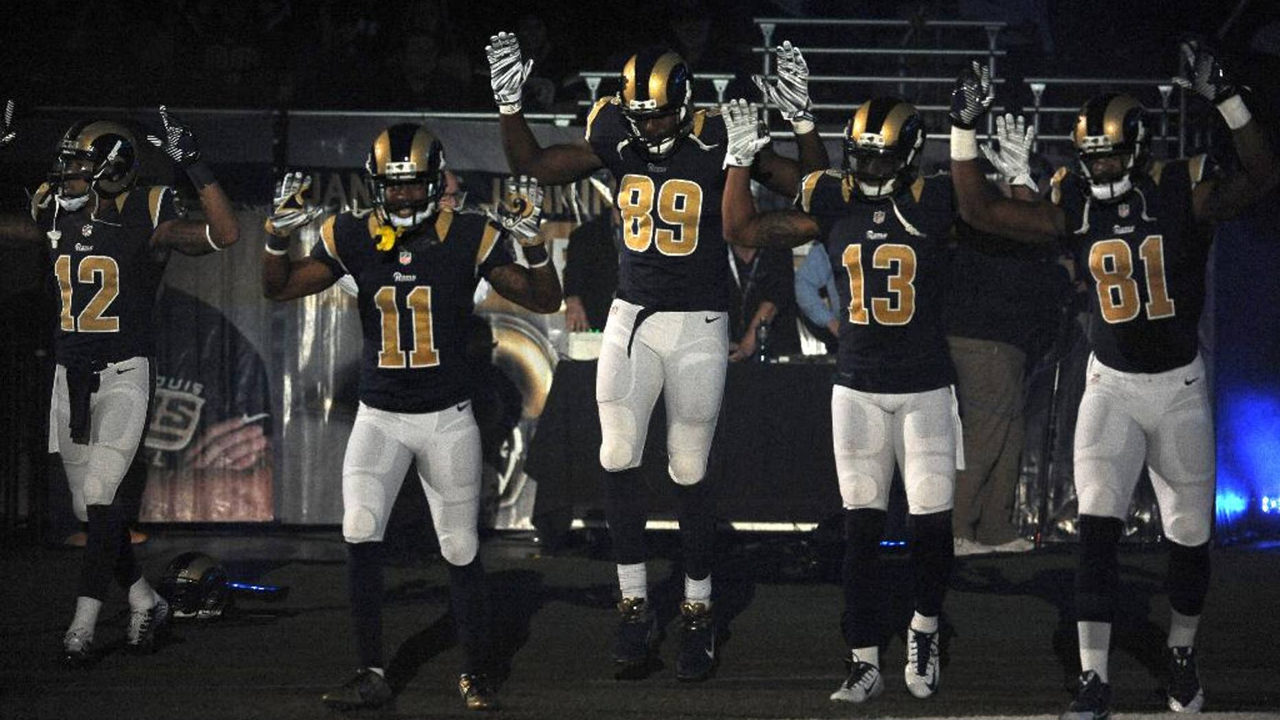 Members of the St. Louis Rams raise their arms as they walk onto the field during introductions before an NFL football game against the Oakland Raiders, Sunday, Nov. 30, 2014, in St. Louis. (AP Photo/L.G. Patterson)