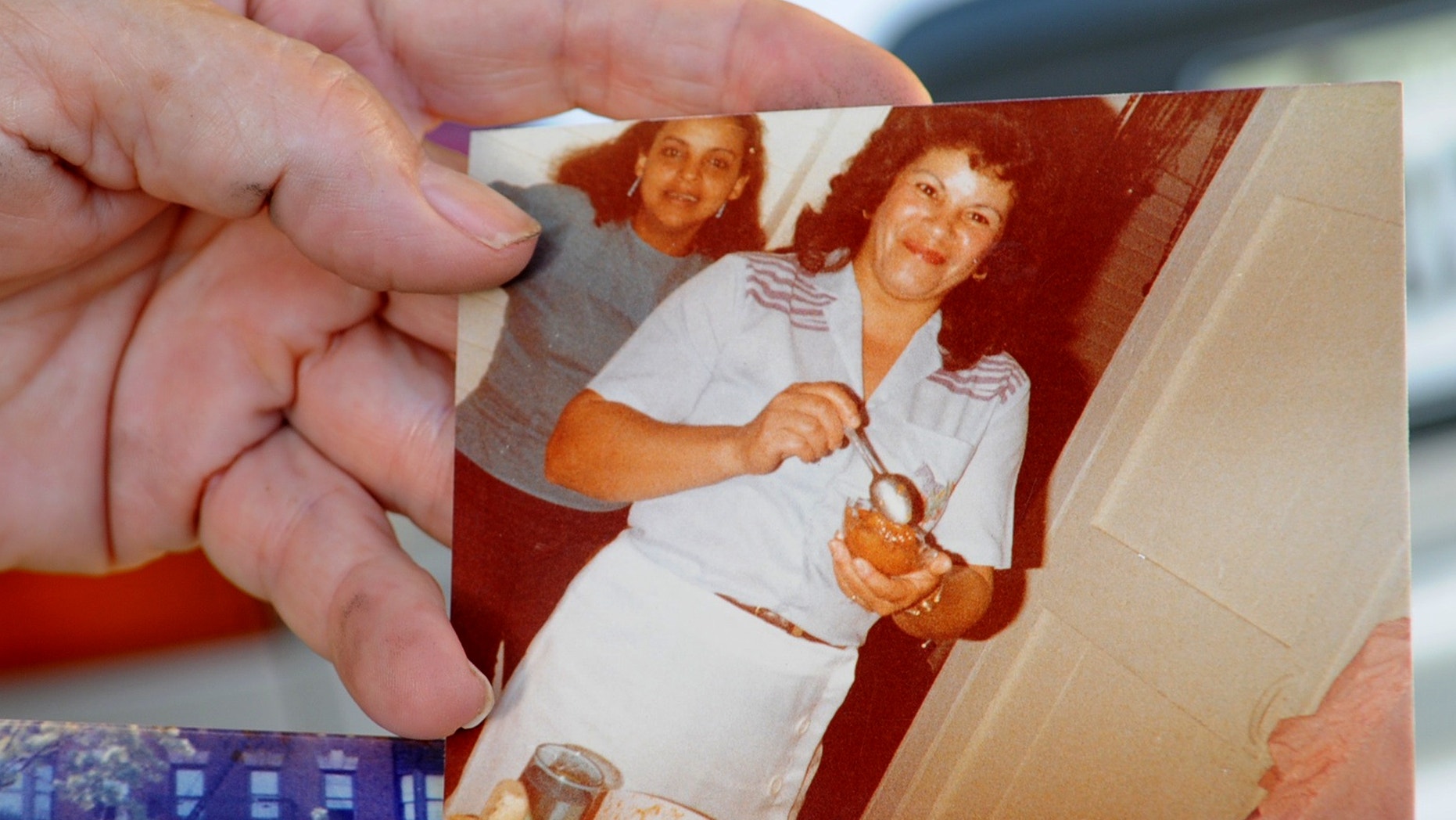 Miladys Ortega shows a photograph of her sister, Yoselyn Ortega, front center, taken some time between 1985 and 1990, at her home in Santiago, Dominican Republic, Saturday, Oct. 27, 2012.