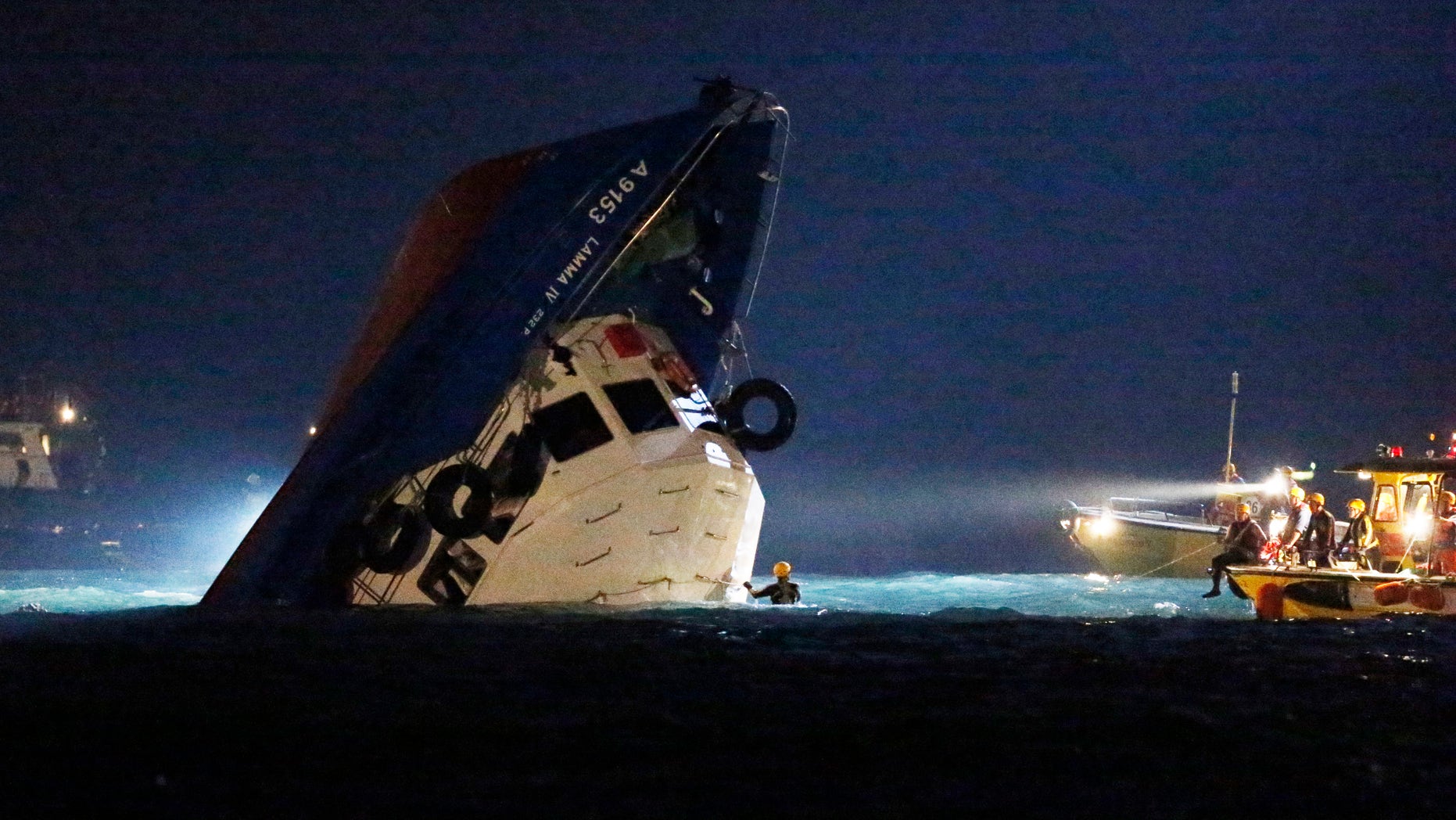 Oct. 2, 2012: Rescuers check on a half submerged boat after it collided Monday night near Lamma Island, off the southwestern coast of Hong Kong Island.