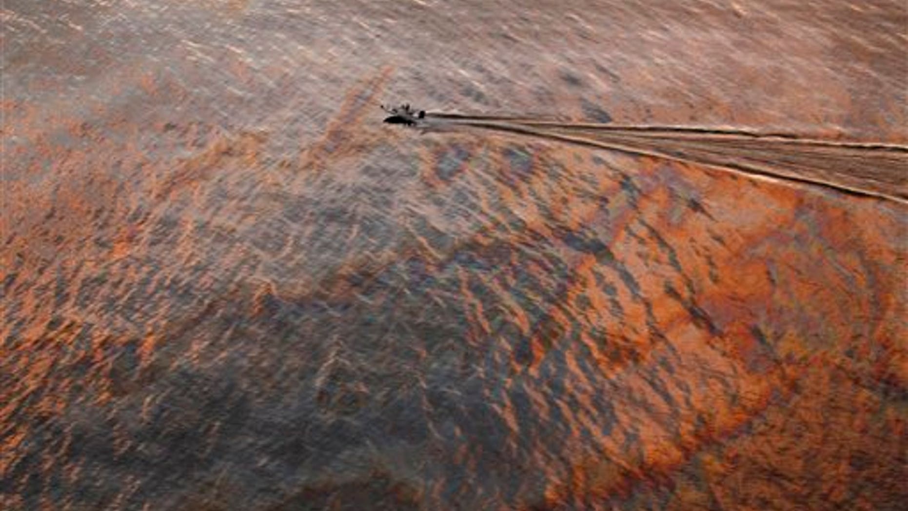 In this July 31, 2010 file photo, a boat motors through oil sheen from the Deepwater Horizon oil spill off East Grand Terre Island, where the Gulf of Mexico meets Barataria Bay, on the Louisiana coast, at sunset. A year after one of the worst environmental disasters in U.S. history, drilling rigs once again are probing the depths of the Gulf of Mexico for oil. But the catastrophic prospect of a spill in oil's next frontier -- the icy waters off Alaska's north coast -- has experts far more concerned. (AP/File)
