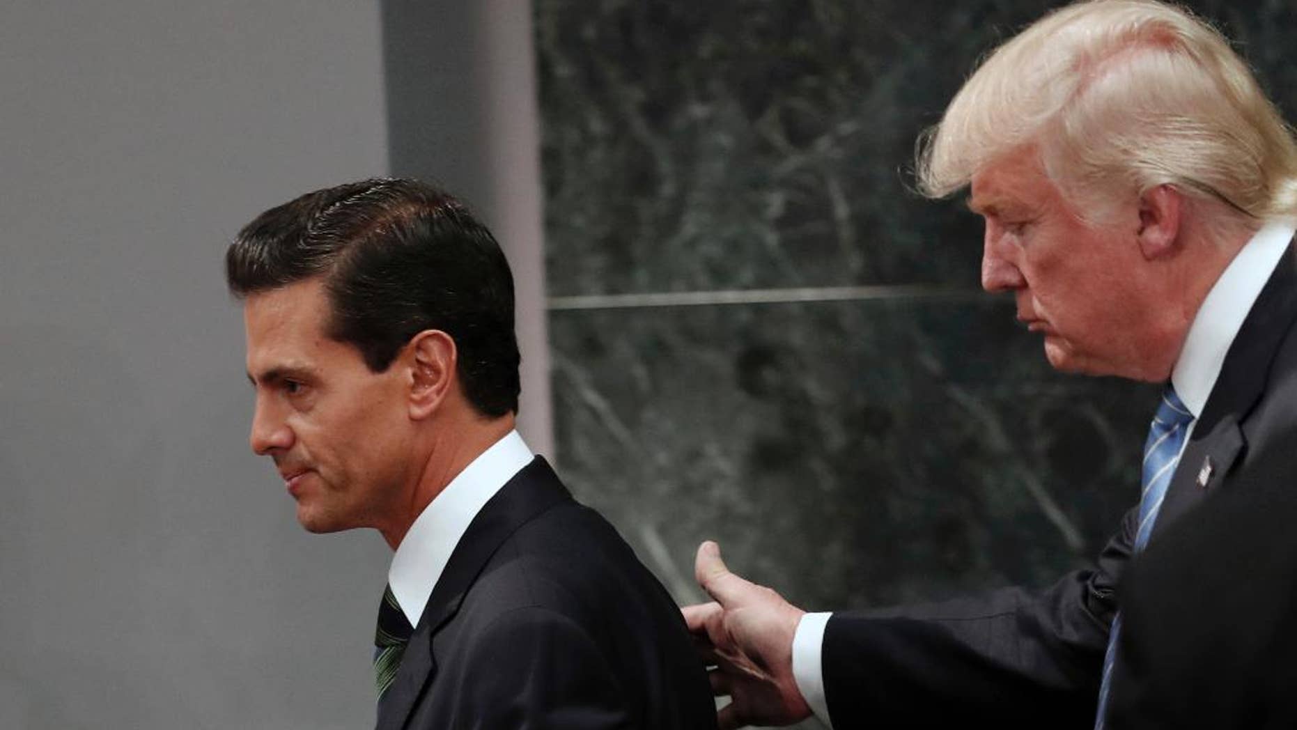 FILE - In this Aug. 31, 2016 file photo, Republican presidential nominee Donald Trump walks with Mexico President Enrique Pena Nieto at the end of their joint statement at Los Pinos, the presidential official residence, in Mexico City. President Donald Trump and Mexican President Enrique Pena Nieto spoke for an hour by phone Friday Jan. 27, 2017 amid rising tensions over the U.S. leader's plans for a southern border wall, administration officials said.(AP Photo/Dario Lopez-Mills, File)