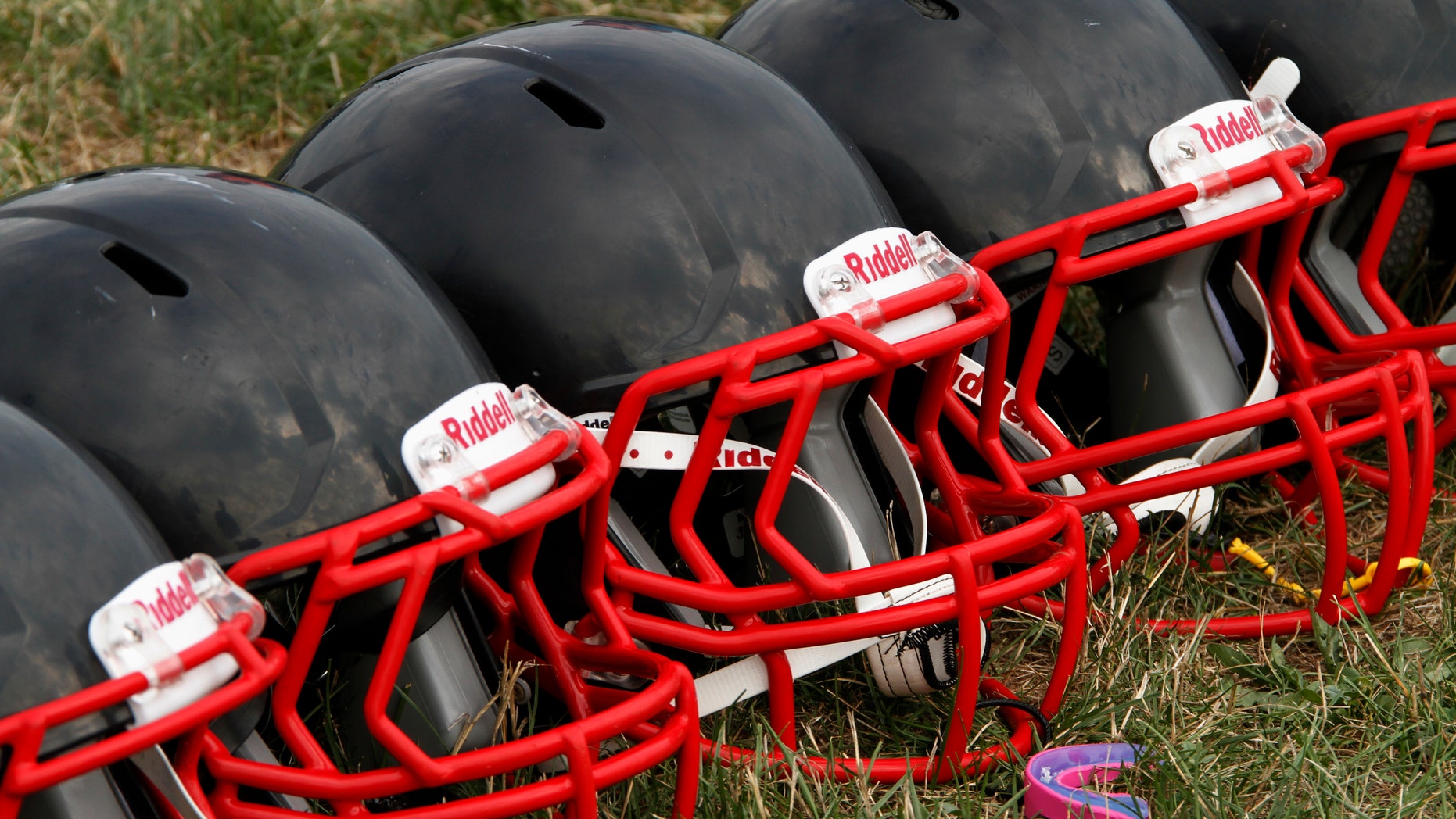 FILE - This Aug. 4, 2012 file photo shows new football helmets that were given to a group of youth football players from the Akron Parents Pee Wee Football League, in Akron, Ohio. It's not just football. A new report says too little is known about concussion risks for young athletes, and it's not clear whether better headgear is an answer. The panel stresses wearing proper safety equipment. But it finds little evidence that current helmet designs, face masks and other gear really prevent concussions, as ads often claim. (AP Photo/Gene J. Puskar, File)