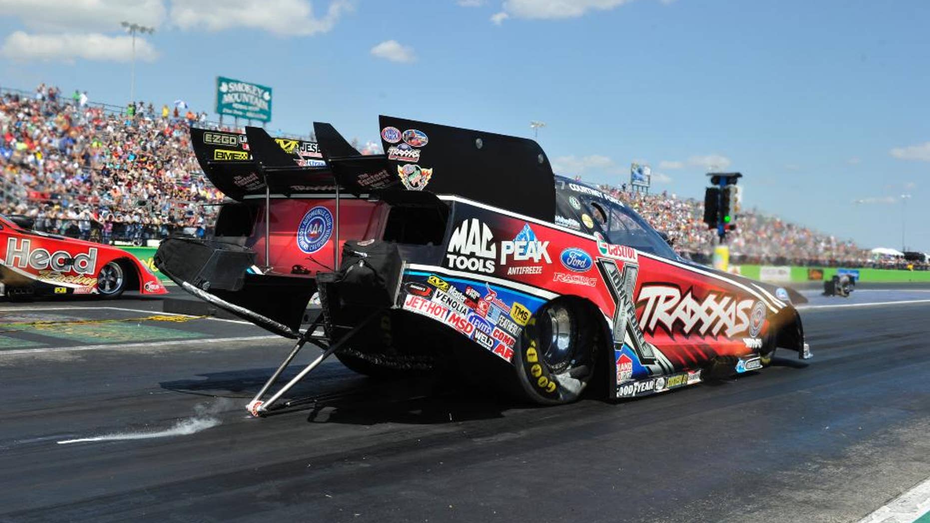 In this photo provided by NHRA, Courtney Force races to her fourth No. 1 qualifying position of the season in Funny Car on Saturday, Sept. 20, 2014, at the AAA Texas NHRA FallNationals drag races at the Texas Motorplex in Ennis, Texas. (AP Photo/NHRA, Robert Grice)