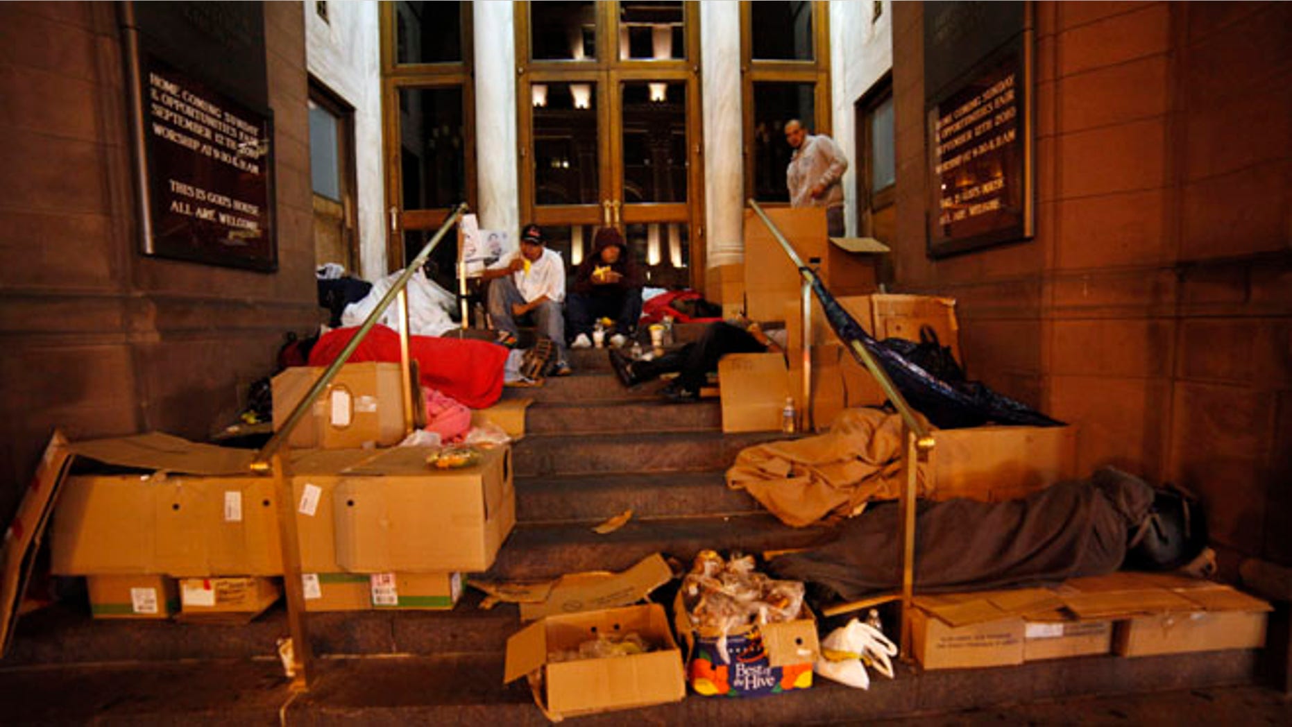 Homeless people eat food donated by a charity organization called HomelessBus.org.