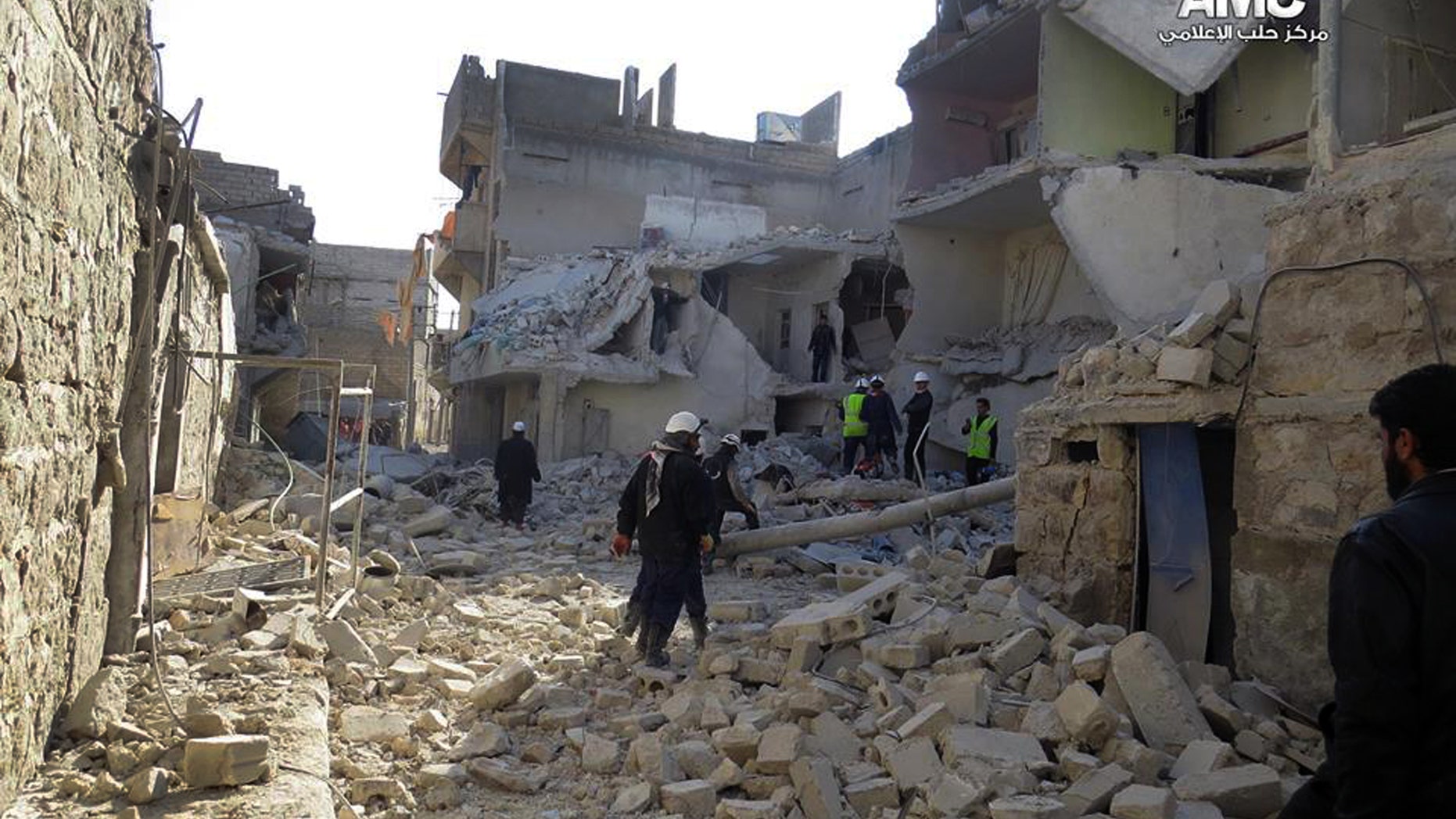 This citizen journalism image provided by Aleppo Media Center (AMC), an anti-Bashar Assad activist group which has been authenticated based on its contents and other AP reporting, shows Syrian rescue workers check the rubble of a destroyed building which was attacked by Syrian forces warplanes, in Aleppo, Syria, Tuesday, Jan. 21, 2014. (AP Photo/Aleppo Media Center, AMC)