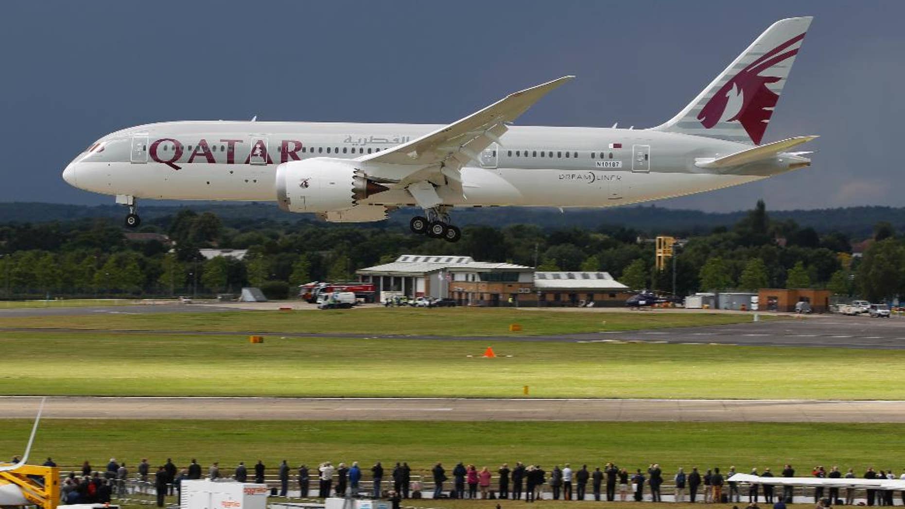 FILE- in this file photo dated Wednesday, July 11, 2012, onlookers watch as a Qatar Airways Boeing 787 Dreamliner lands during an aerial display at the Farnborough International Airshow, in Farnborough, England. The state-owned Commercial Aircraft Corp. of China, known as Comac, announced plans this week at Farnborough airshow 2016, for a wide-body aircraft to be built with state-owned Russian maker United Aircraft Corporation, striking at the heart of the market leaders Airbus and Boeing. (AP Photo/Lefteris Pitarakis, FILE)