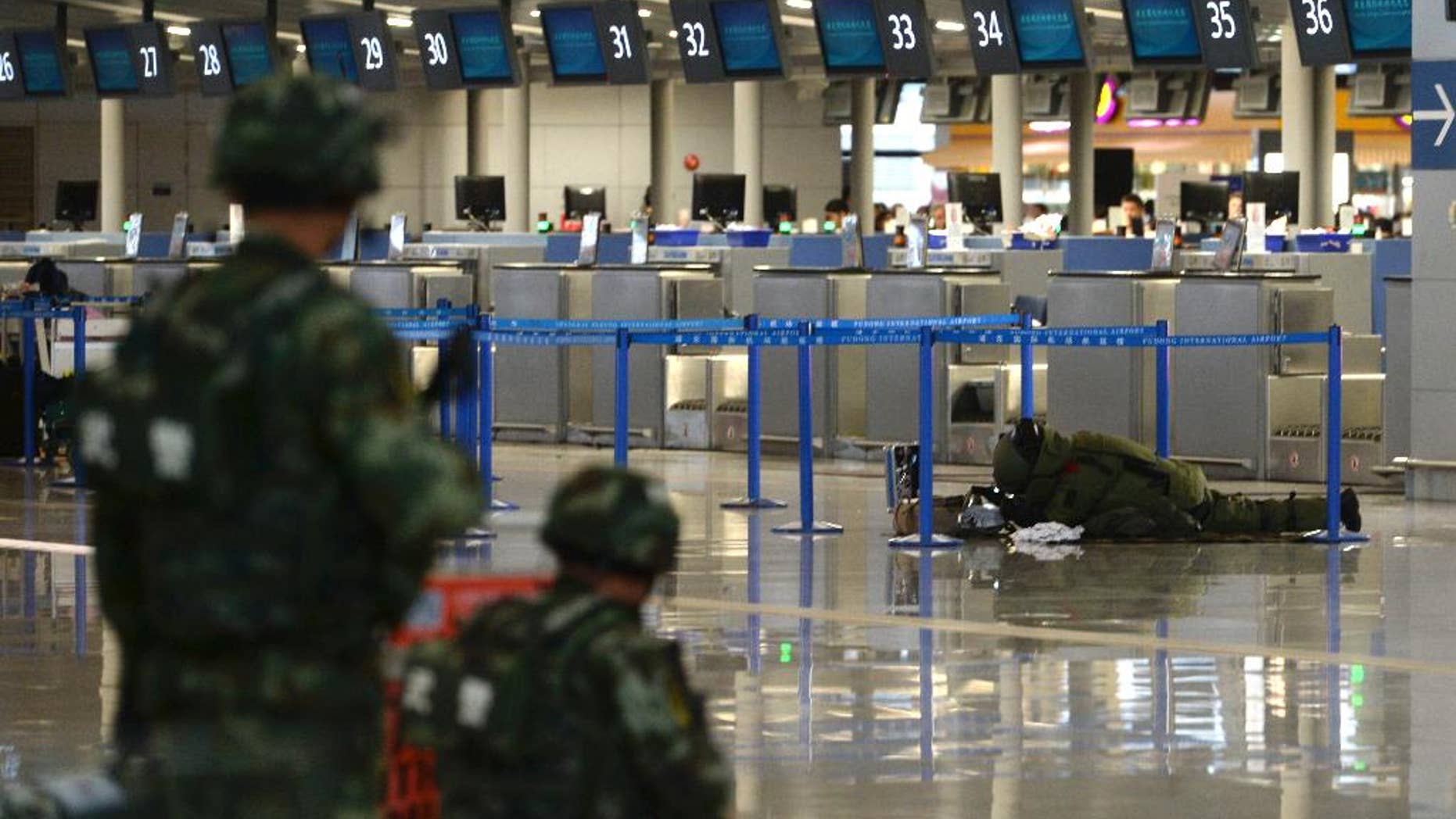 A demolition expert prepares to dismantle a suspected bomb in a closed off area after an explosion at Shanghai's Pudong airport Sunday.