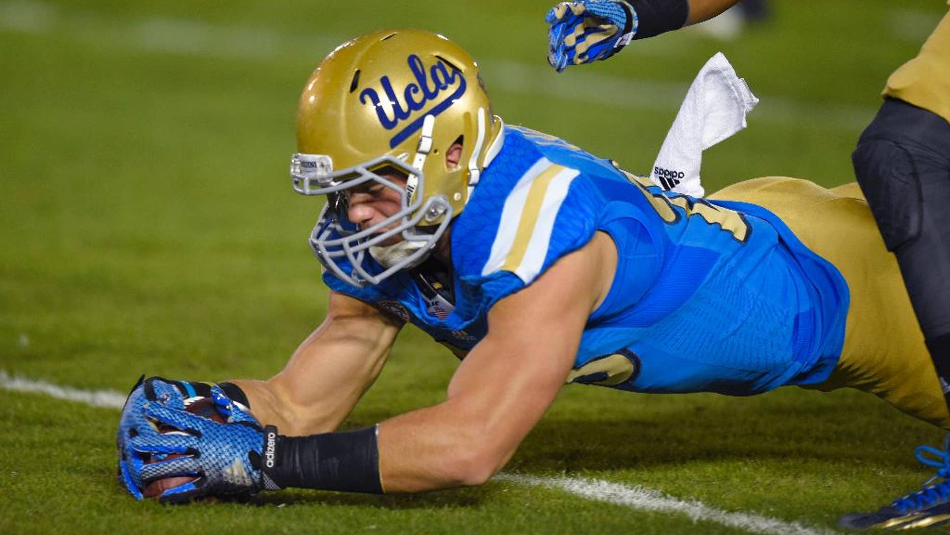 UCLA fullback Taylor Lagace recovers a punt that was fumbled by Southern California's Nelson Agholor during the first half of an NCAA college football game, Saturday, Nov. 22, 2014, in Pasadena, Calif. (AP Photo/Mark J. Terrill)
