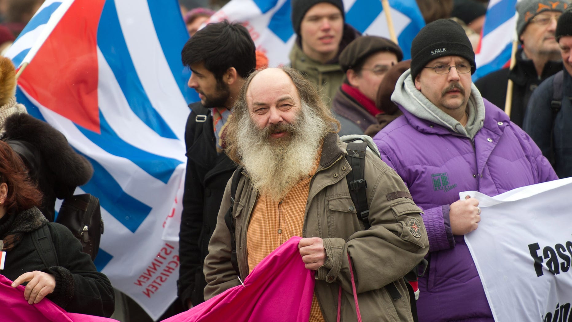 FILE - In this Feb. 13, 2013 file picture Lothar Koenig, center, takes part in a demonstration in Dresden, eastern Germany, to commemorate and remember the victims of WWII aerial bombing. The German priest, due to stand trial Thursday Aoril 4, 2013 for allegedly orchestrating attacks on police at an anti-Nazi demonstration, says his conviction would send a chilling message to people opposed to right-wing extremists.Lothar Koenig faces several years in prison if convicted of serious breach of the peace, attempting to obstruct justice and attempted coercion at a protest in the eastern city of Dresden two years ago.Koenig denies the charges and insists that he was part of a group who trying peacefully to stop thousands of neo-Nazis from marching through Dresden Feb. 19, 2011. (AP Photo/dpa, Arno Burgi,File)