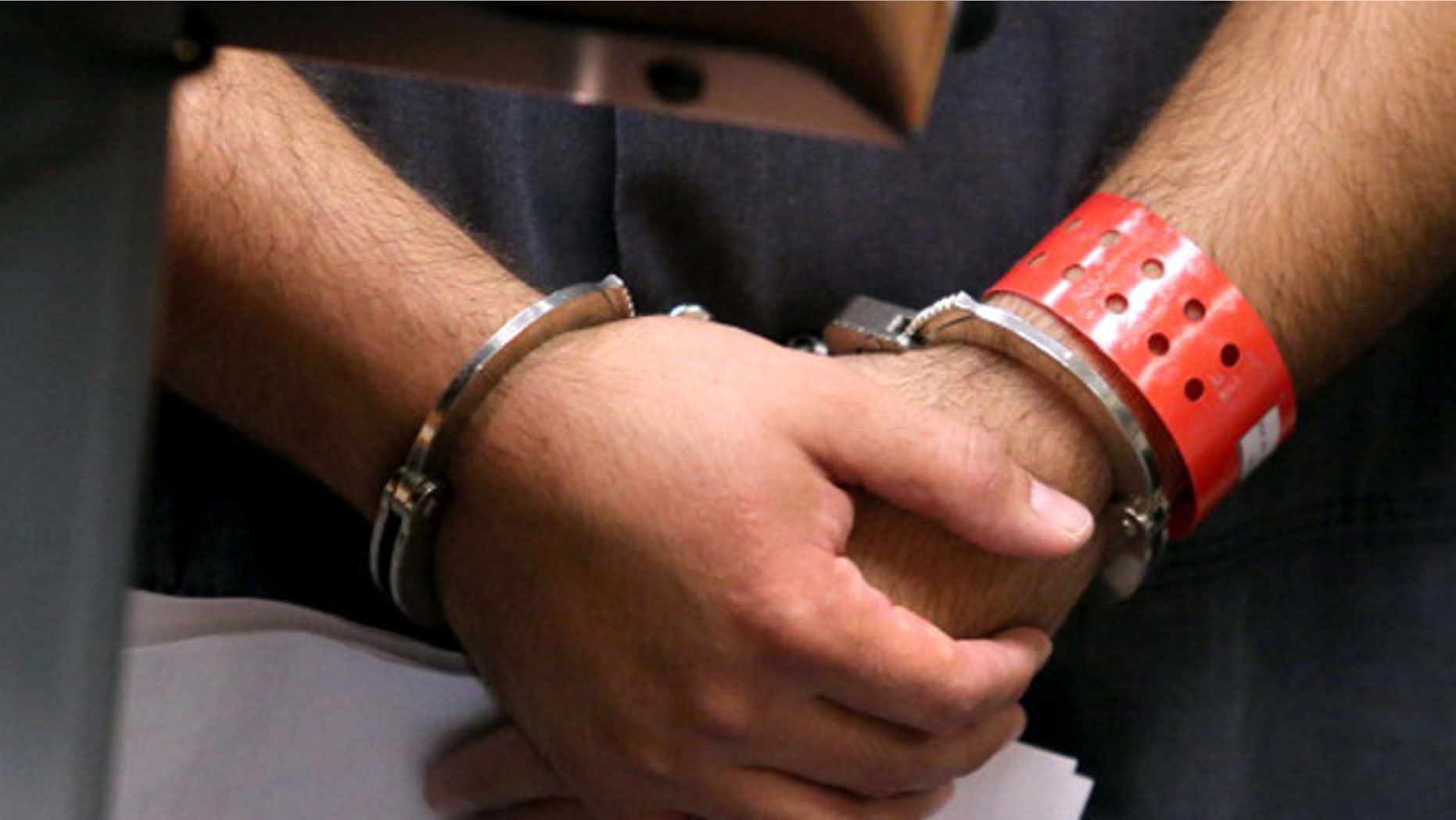 SANFORD, FL - NOVEMBER 19: Detail of the handcuffed hands of George Zimmerman, the acquitted shooter in the death of Trayvon Martin, faces a Seminole circuit judge during a first-appearance hearing on charges including aggravated assault stemming from a fight with his girlfriend November 19, 2013 in Sanford, Florida. Zimmerman, 30, was arrested after police responded to a domestic disturbance call at a house. He was acquitted in July of all charges in the shooting death of unarmed, black teenager, Trayvon Martin. (Photo by Joe Burbank-Pool/Getty Images)