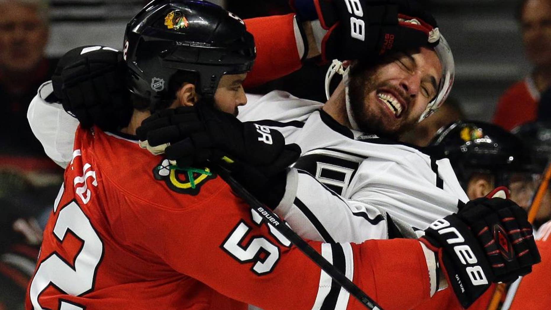 Chicago Blackhawks left wing Brandon Bollig (52) and Los Angeles Kings left wing Dwight King (74) fight during the first period in Game 7 of the Western Conference finals in the NHL hockey Stanley Cup playoffs Sunday, June 1, 2014, in Chicago. (AP Photo/Nam Y. Huh)