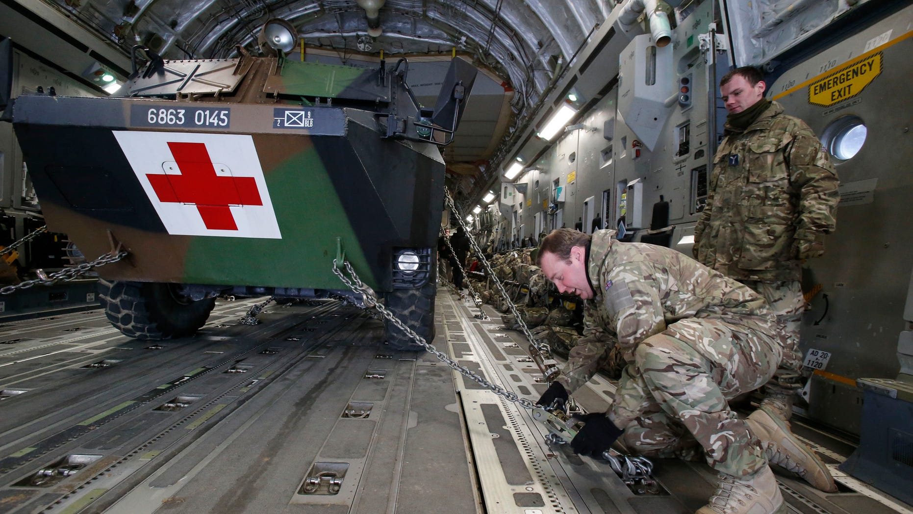 A British military personnel fix a French army medical armoured personnel carrier inside a British C17 transport plane prior to take off at army base in Evreux, 90 kms (56 mls) north of Paris, Monday, Jan. 14, 2013. British military equipment was readied for deployment in Mali on Monday as international intervention in the country increased following advances in the north by Islamic extremists with reported links to Al-Qaida. Two C-17 transport planes have arrived at the French military airbase at Evreux, bound for Mali. Two C-17 transport planes have arrived at the French military airbase at Evreux, bound for Mali. (AP Photo/Michel Euler)
