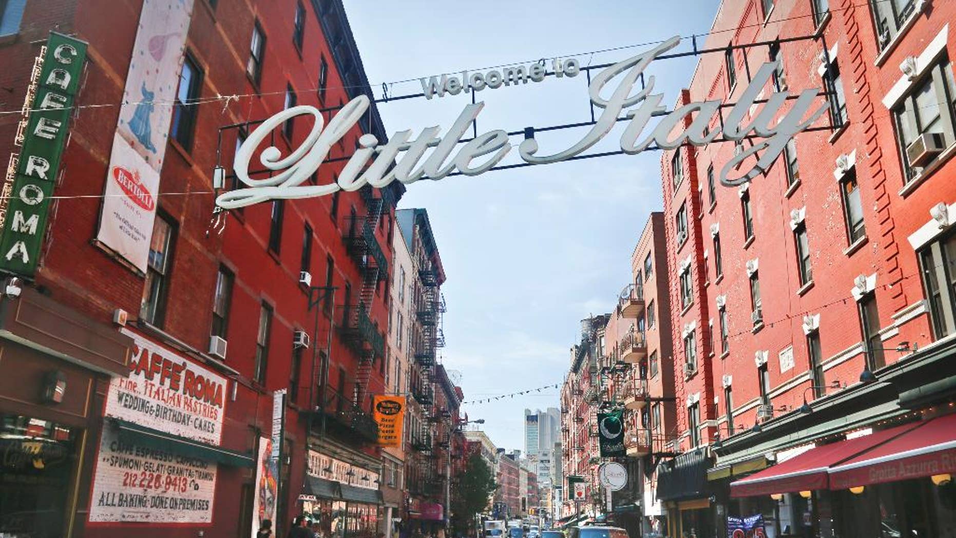 An overhead sign welcomes visitors to Little Italy, near the Cafe Roma, at the corner of Broome and Mulberry Streets.